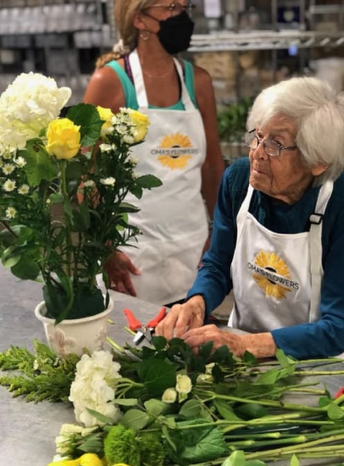 Senior doing flower arrangement at {{location_name}} in {{location_city}}