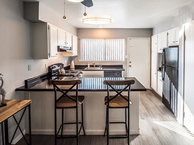 Kitchen with counter seating and plank flooring at The Eleven Hundred in Sacramento, California