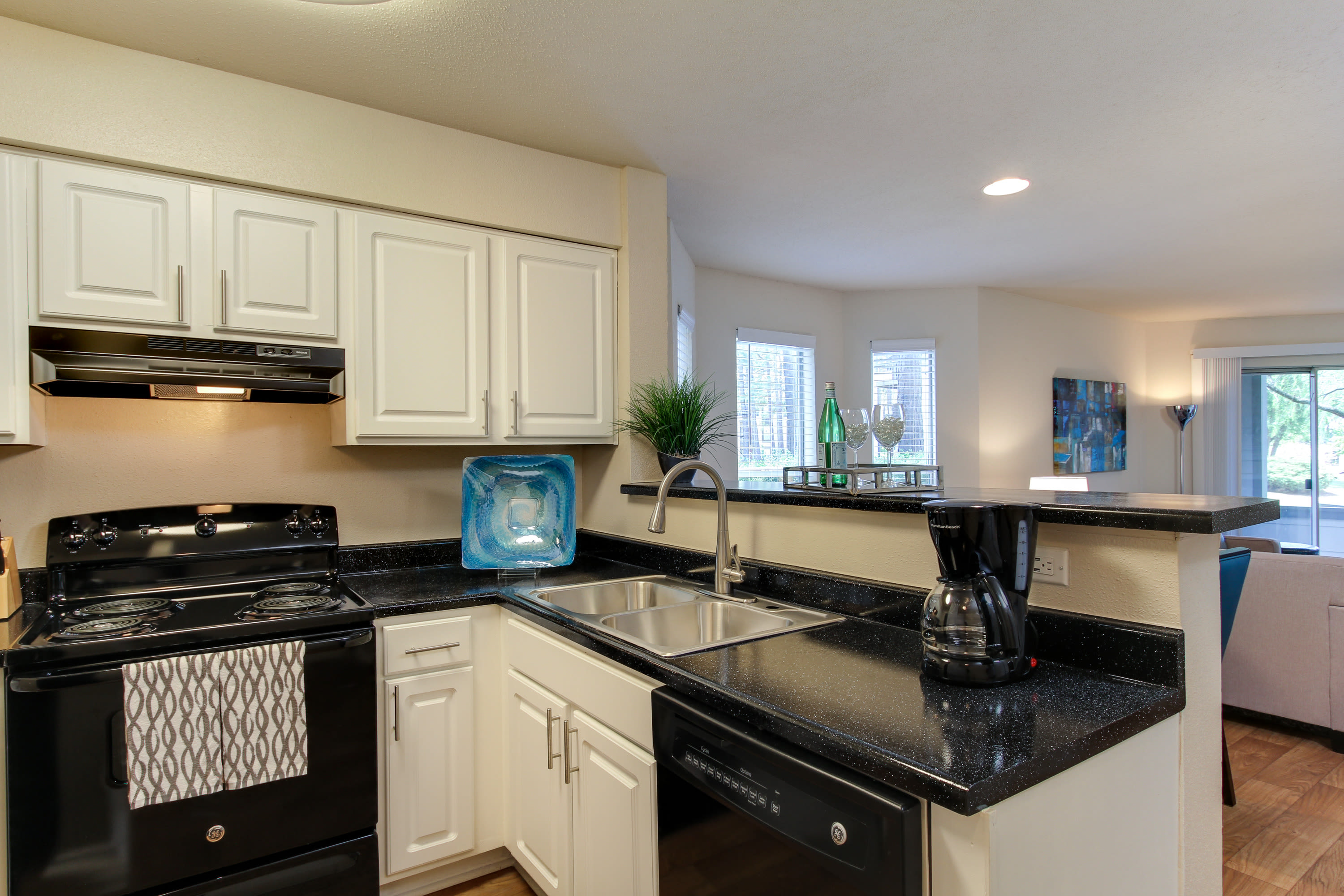 Kitchen with stainless-steel appliances and white cabinetry at Mission University Pines in Durham, North Carolina