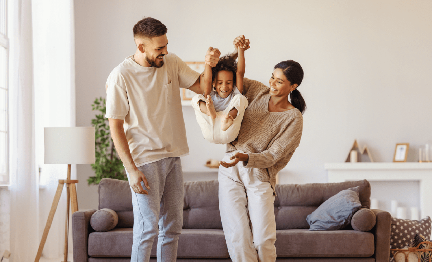 A couple lovingly lifting their child up in their living room at Western Wealth Communities in Phoenix, Arizona