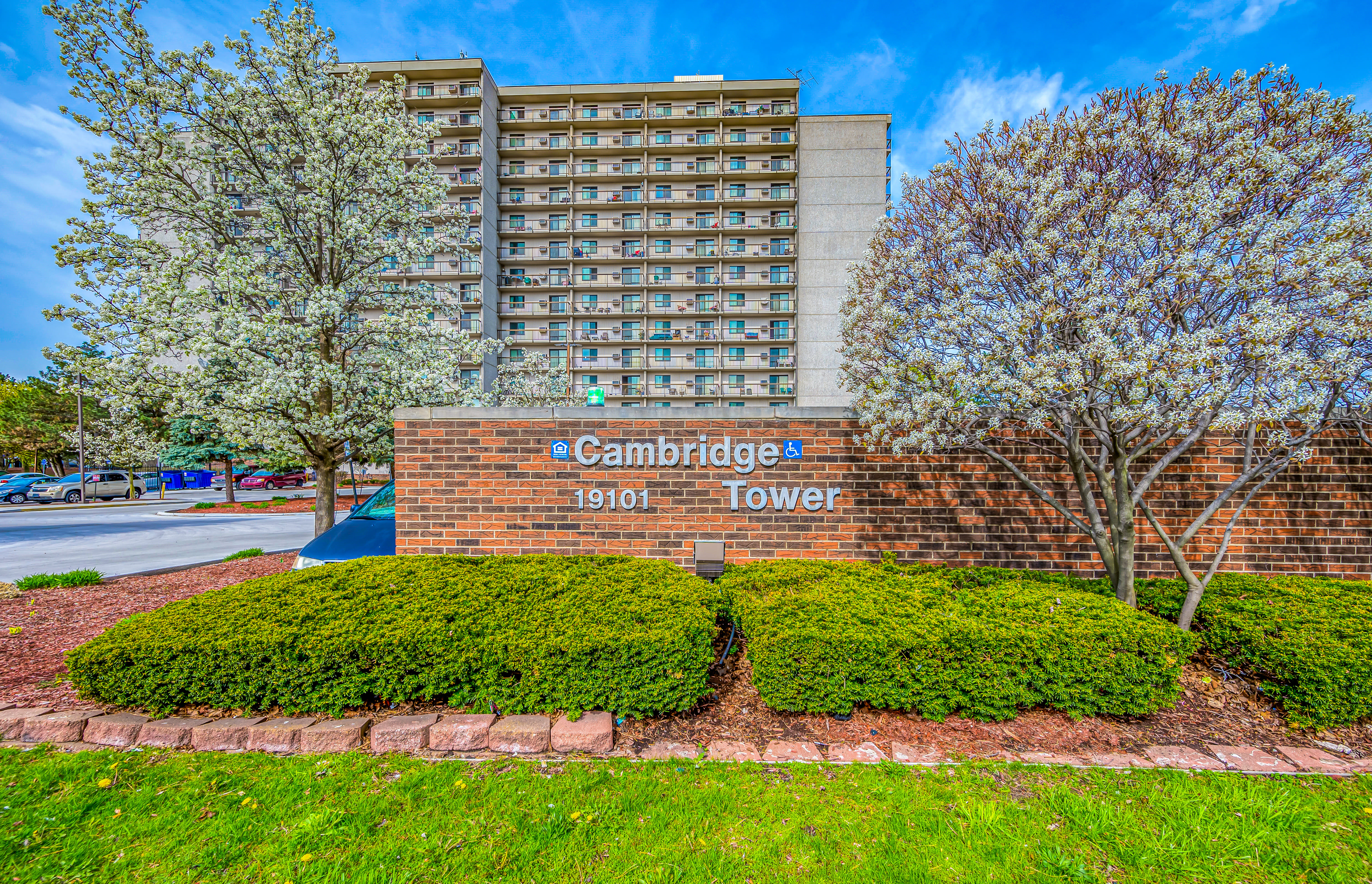 Exterior grounds and sidewalk with mountains in the distance at Cambridge Towers in Detroit, Michigan