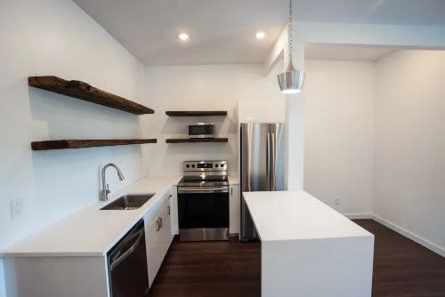 Stainless steel appliances and live edge shelves in the student housing at Campus Prime in Syracuse, New York