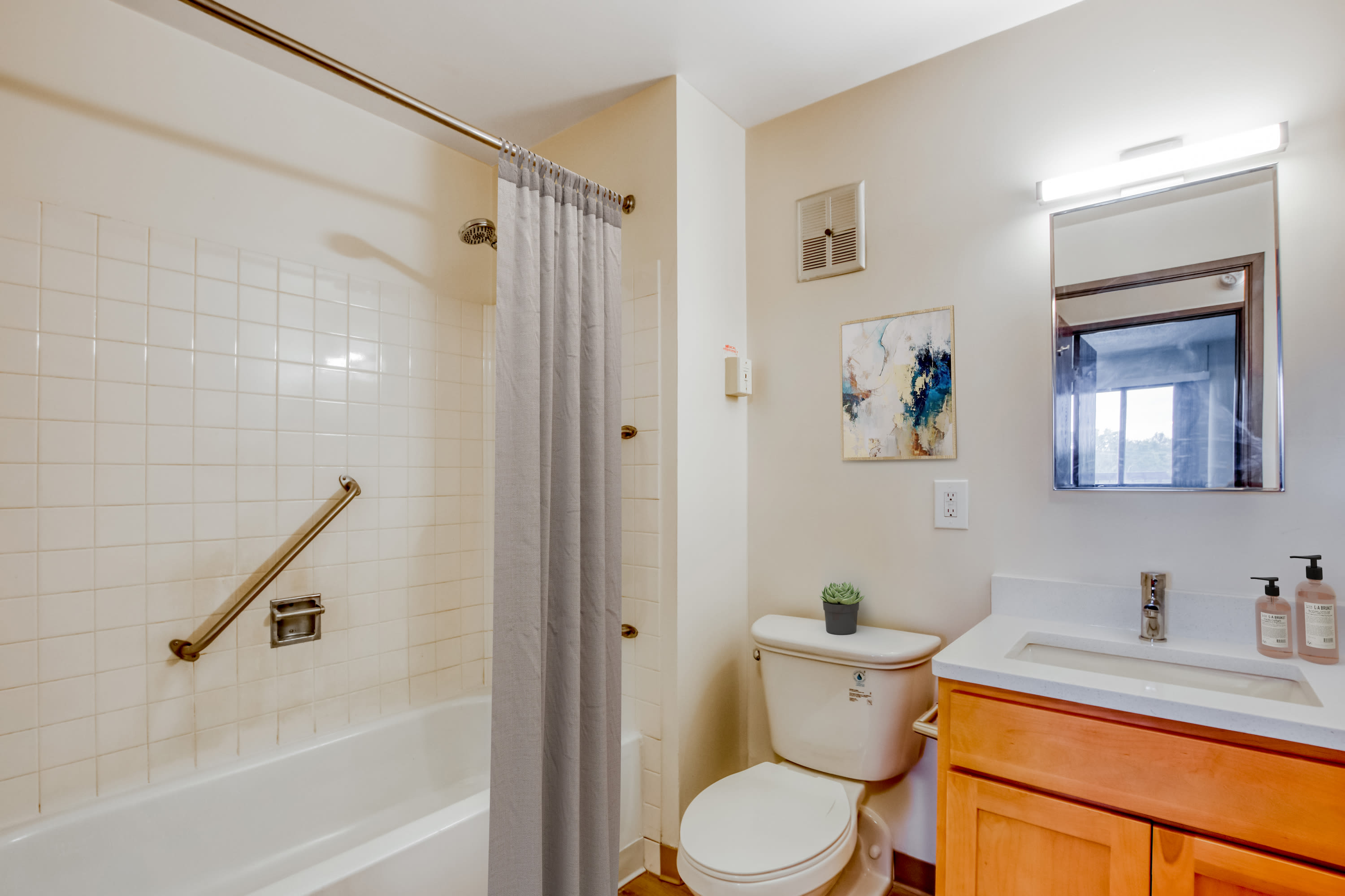 Bathroom with a vanity and tub/shower combination in a model home at Bowin Place in Detroit, Michigan