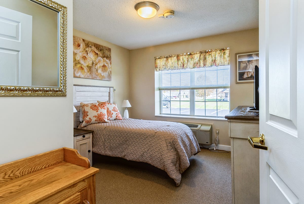 Resident apartment bedroom with floral decorations at Trustwell Living at Oakley Place in Greenville, Ohio