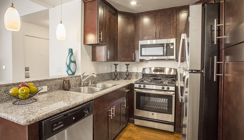 Kitchen with stainless-steel appliances at The Jessica Apartments in Los Angeles, California