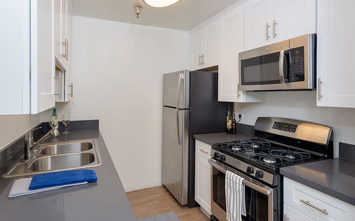 Model kitchen with white cupboards at The Jessica Apartments in Los Angeles, California