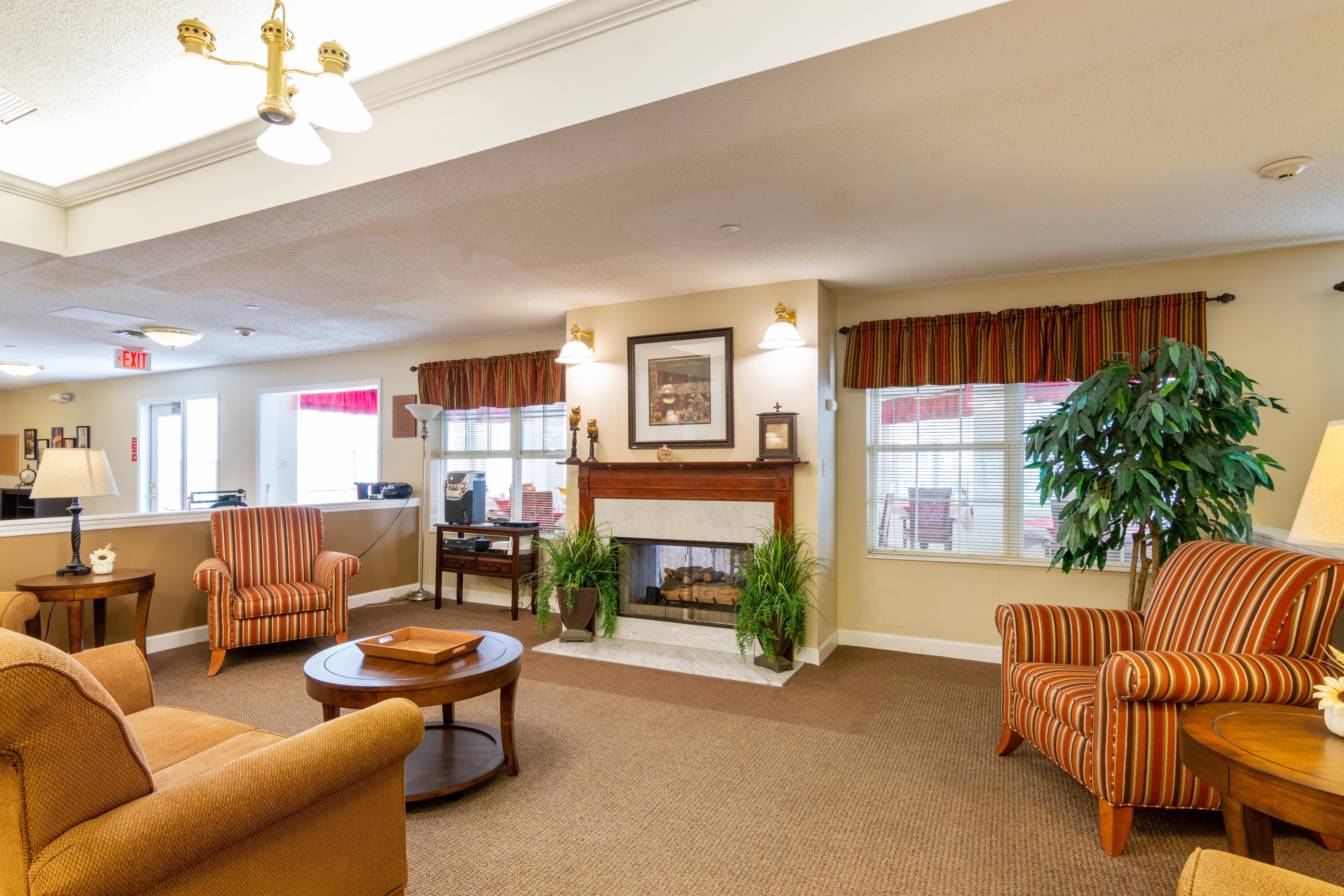 Resident lounge with armchairs and fireplace at Trustwell Living at Kingsbury Place in Defiance, Ohio