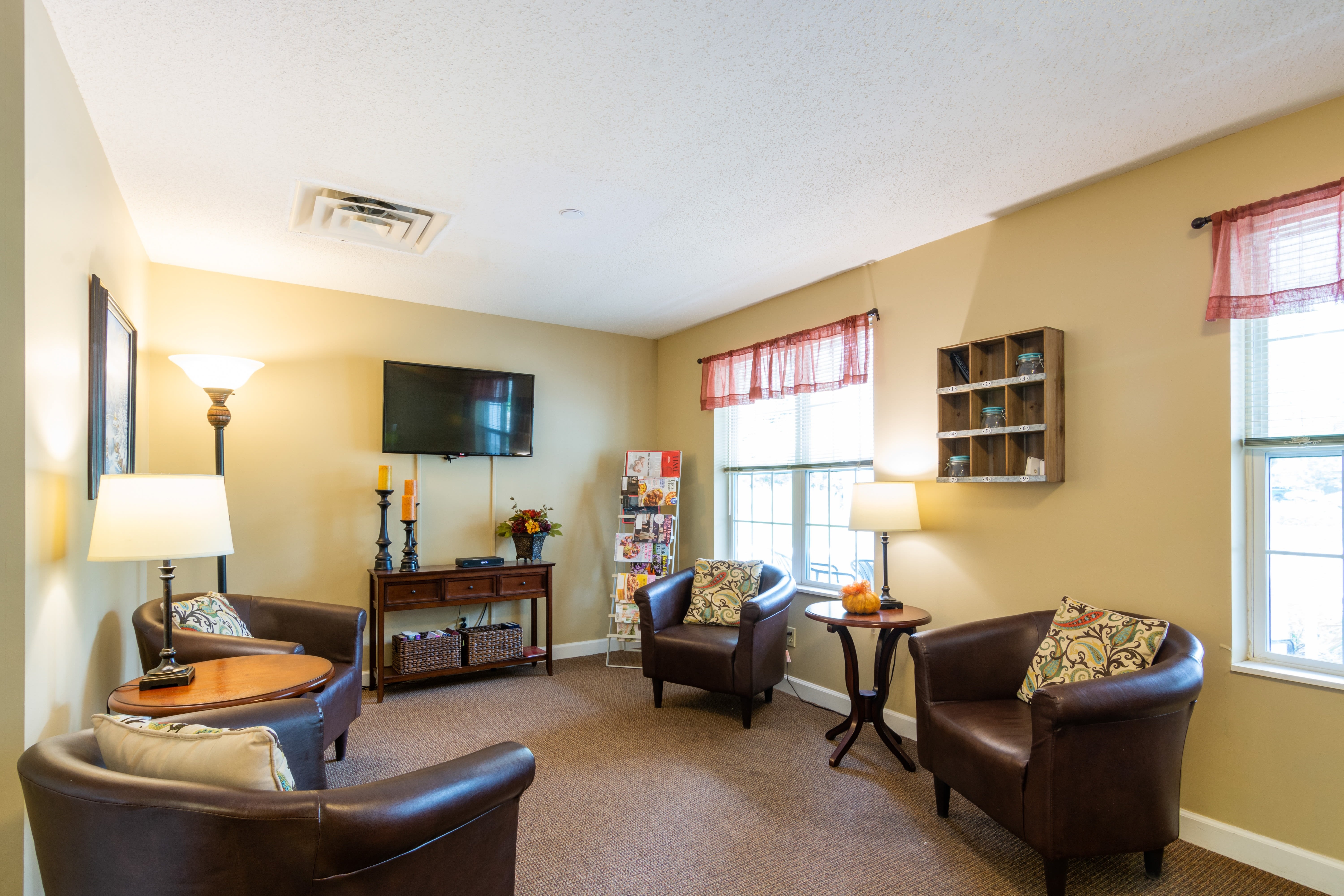 Resident lounge area with leather seating and large television at Trustwell Living at Kingsbury Place in Defiance, Ohio