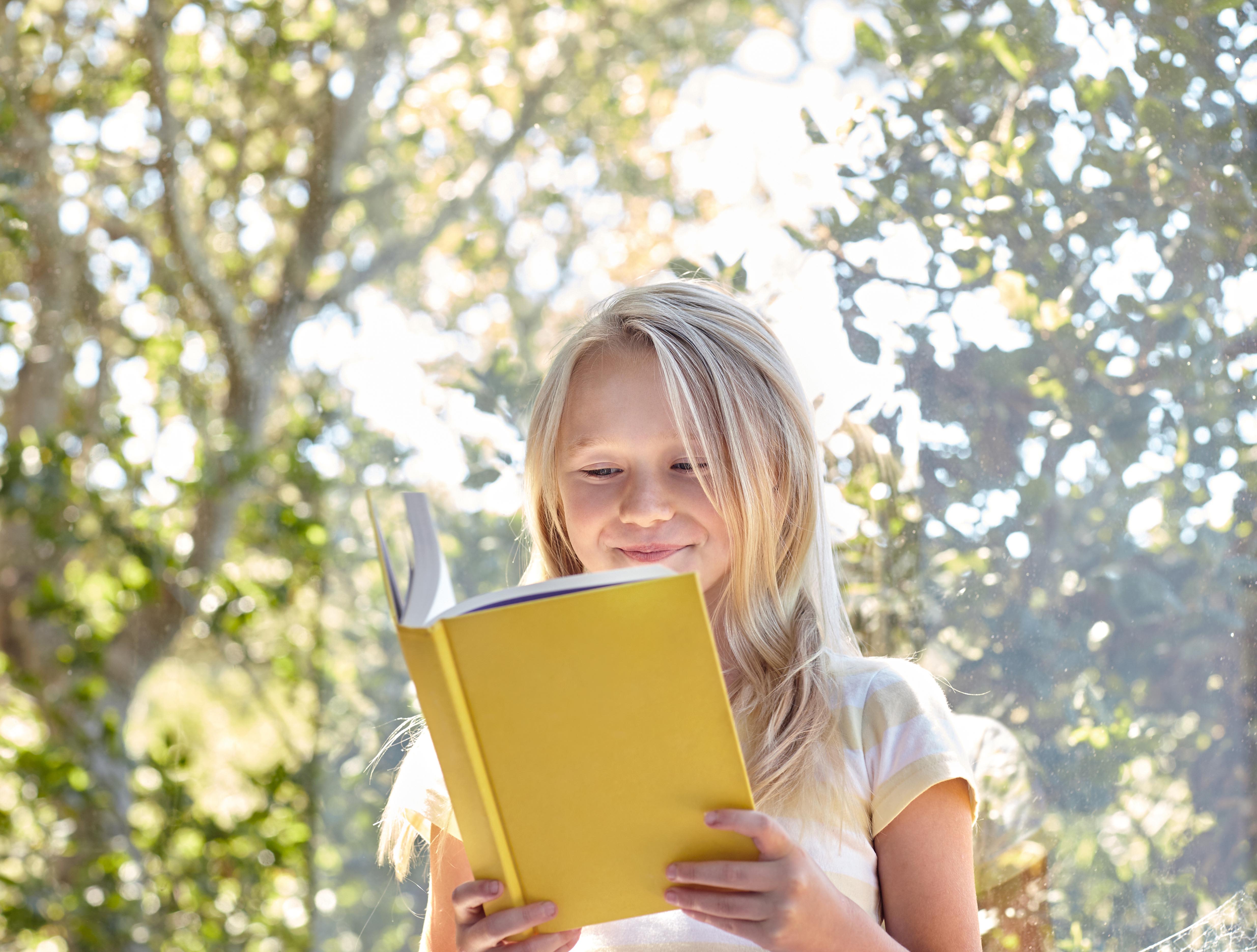 A child reading in the park near Arcadia at Rivers Edge in Medford, Massachusetts