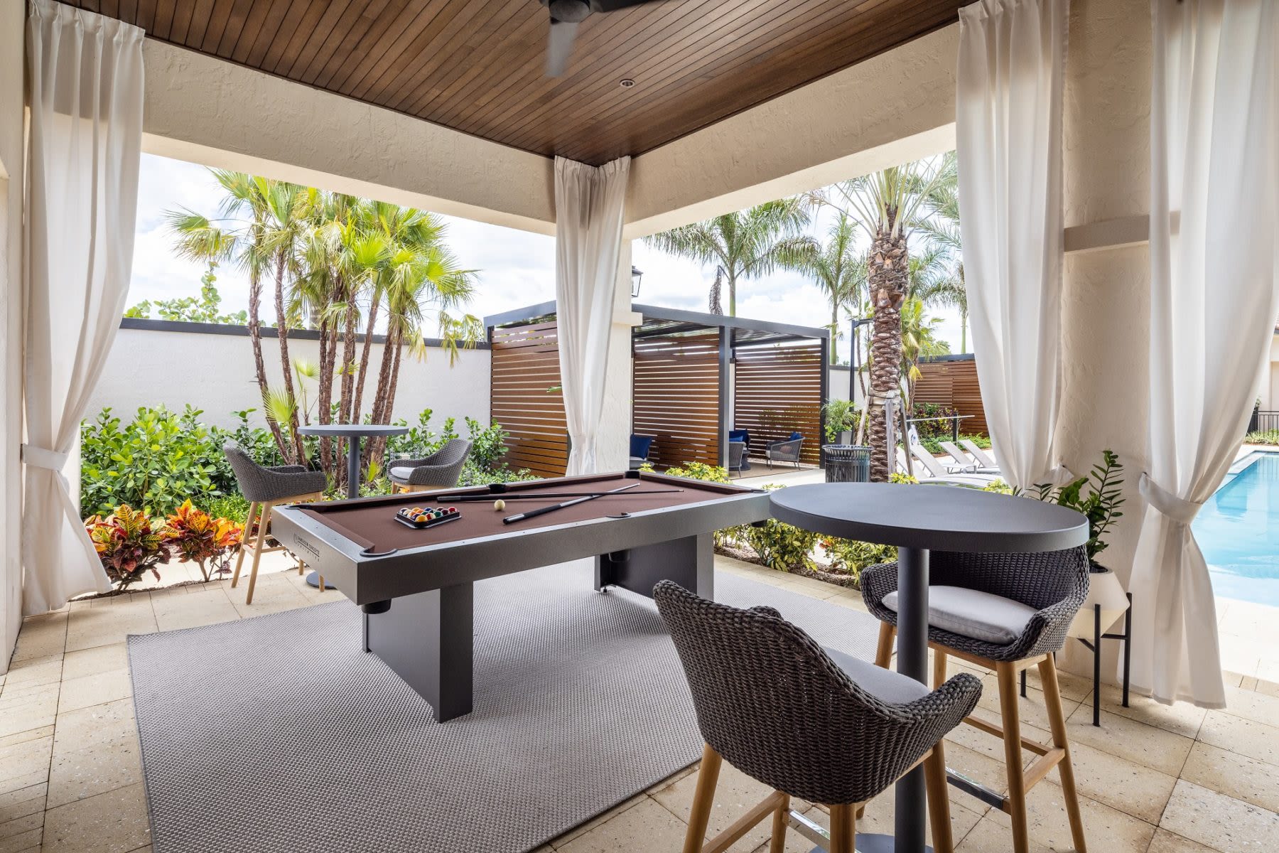covered billiards table by the pool at Locklyn West Palm in West Palm Beach, Florida