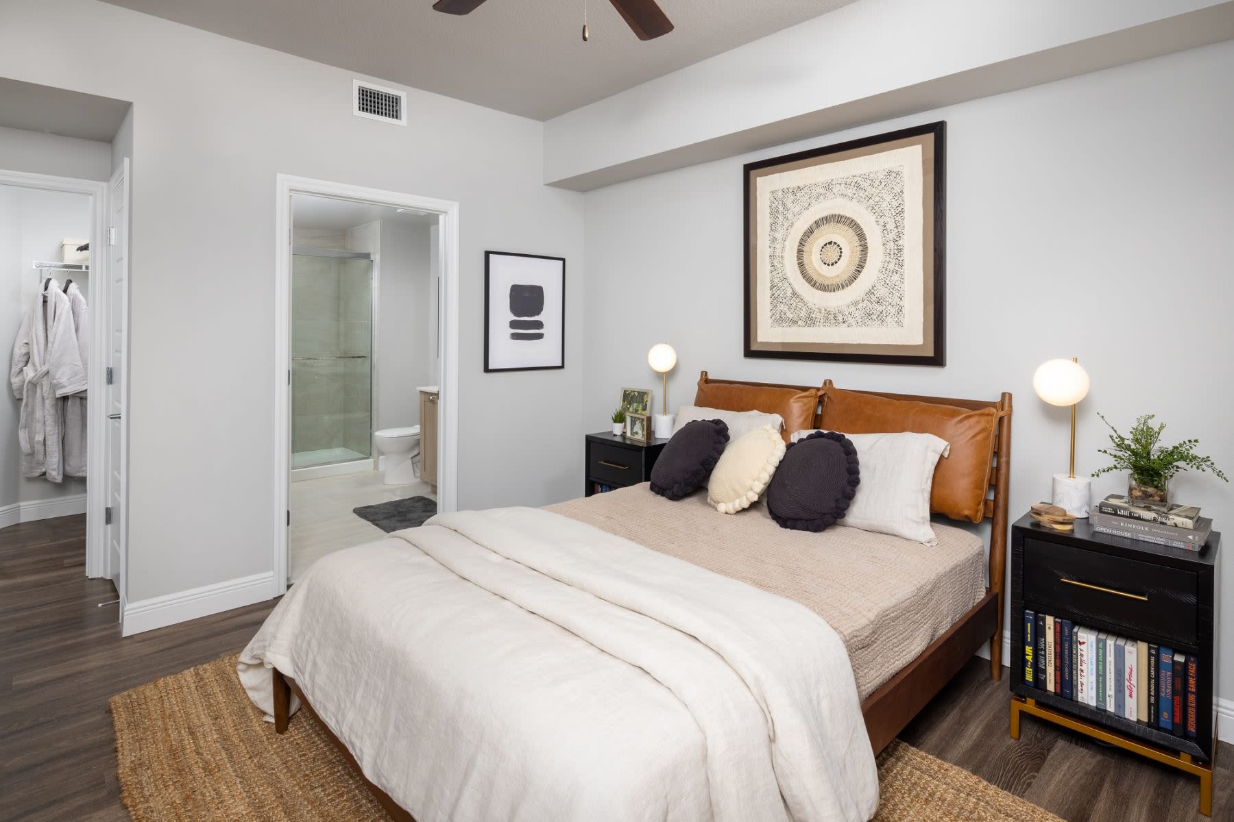Step into a furnished apartment model bedroom at Locklyn West Palm in West Palm Beach, Florida, featuring natural light, contemporary furnishings, and wood-style flooring
