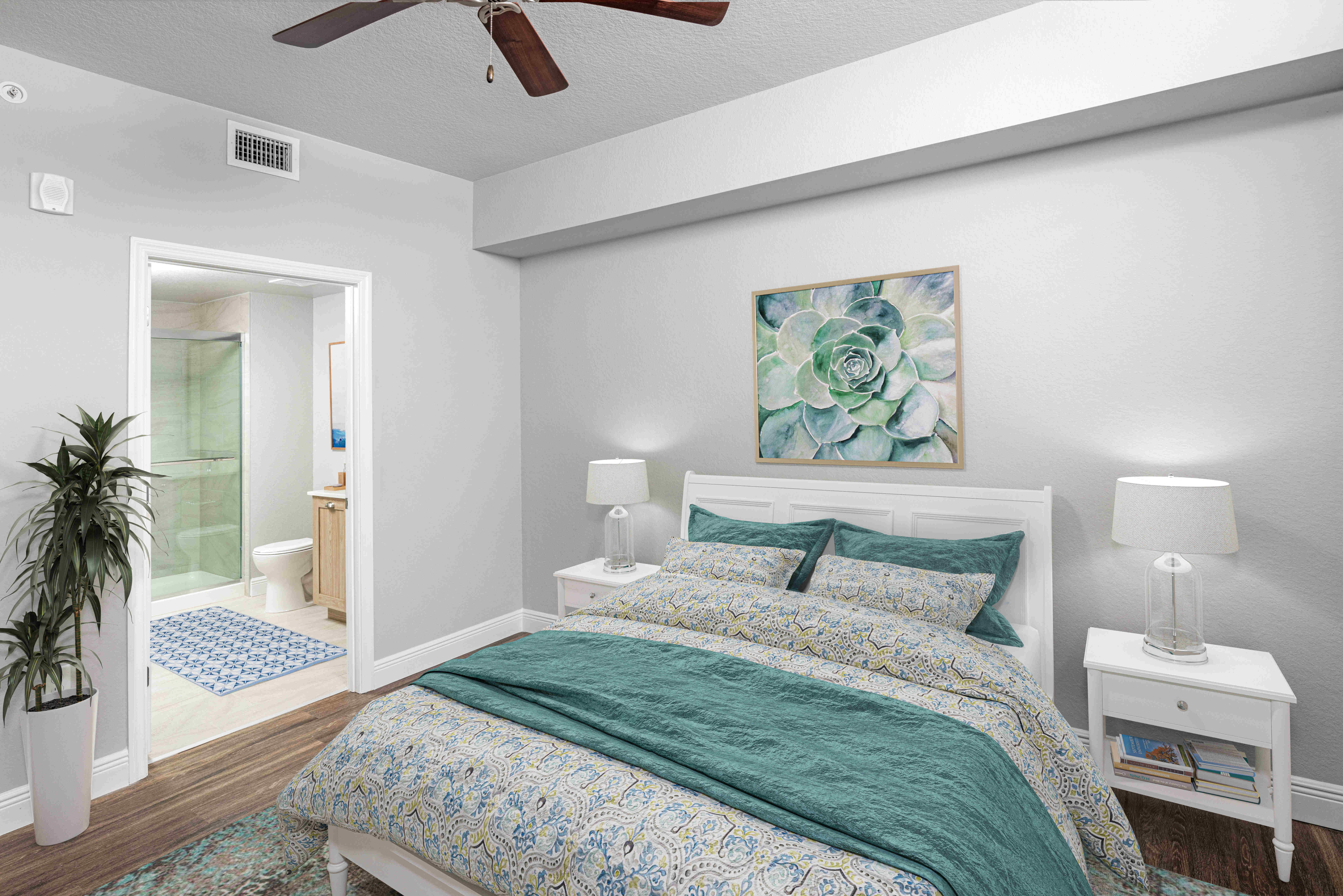 Indulge in the comfort of a furnished apartment model bedroom at Locklyn West Palm in West Palm Beach, Florida, adorned with natural light, modern furnishings, and wood-style flooring