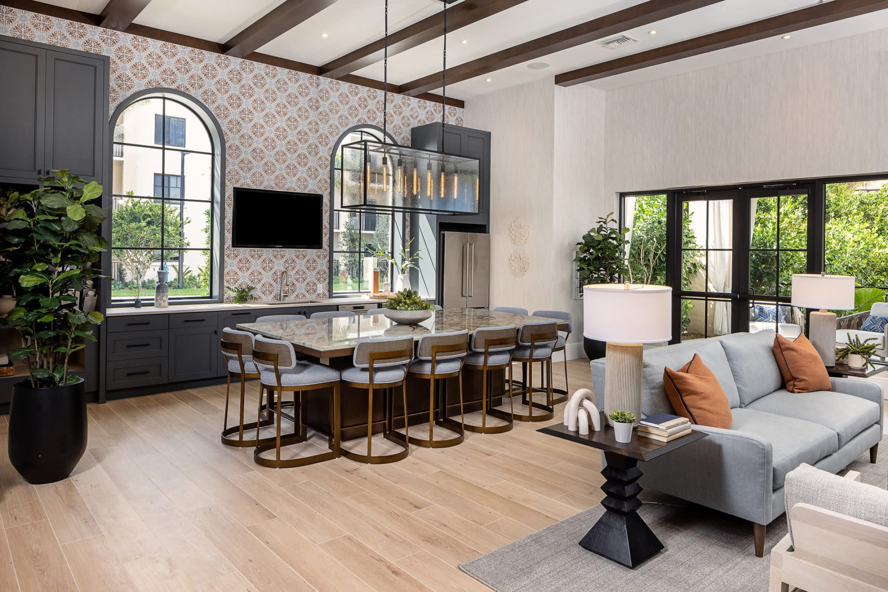 A furnished clubhouse with abundant natural light, modern furnishings, and wood-style flooring at Locklyn West Palm in West Palm Beach, Florida