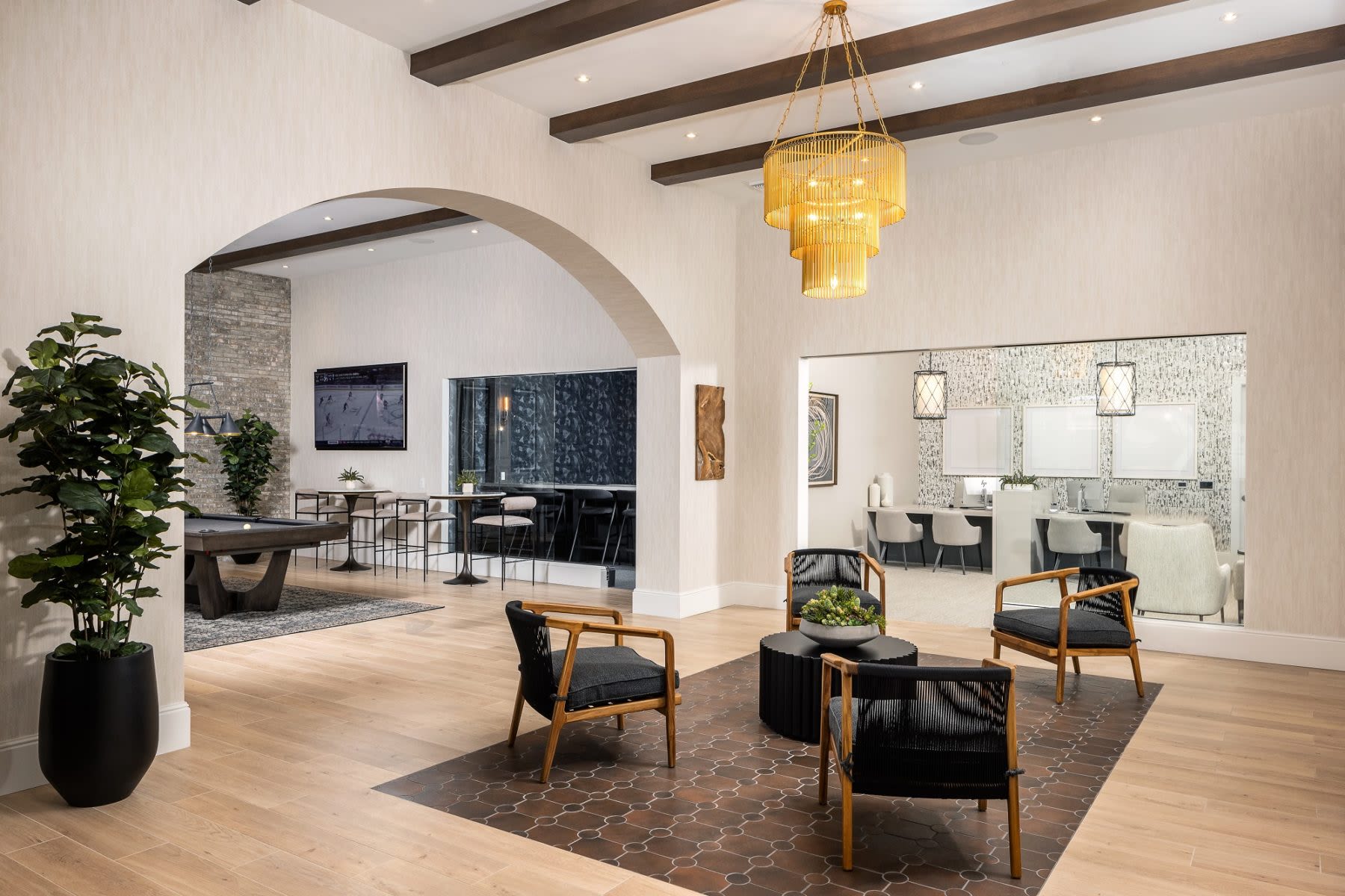 Discover a well-appointed furnished clubhouse featuring natural light, modern furnishings, and elegant wood-style flooring at Locklyn West Palm in West Palm Beach, Florida