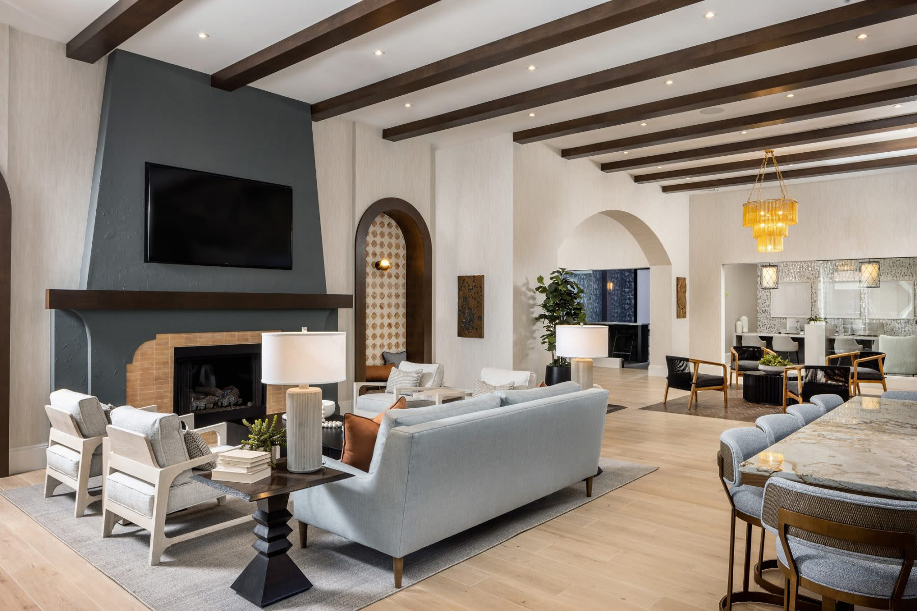Relax and socialize in a furnished clubhouse designed with natural light, modern furnishings, and sleek wood-style flooring at Locklyn West Palm in West Palm Beach, Florida