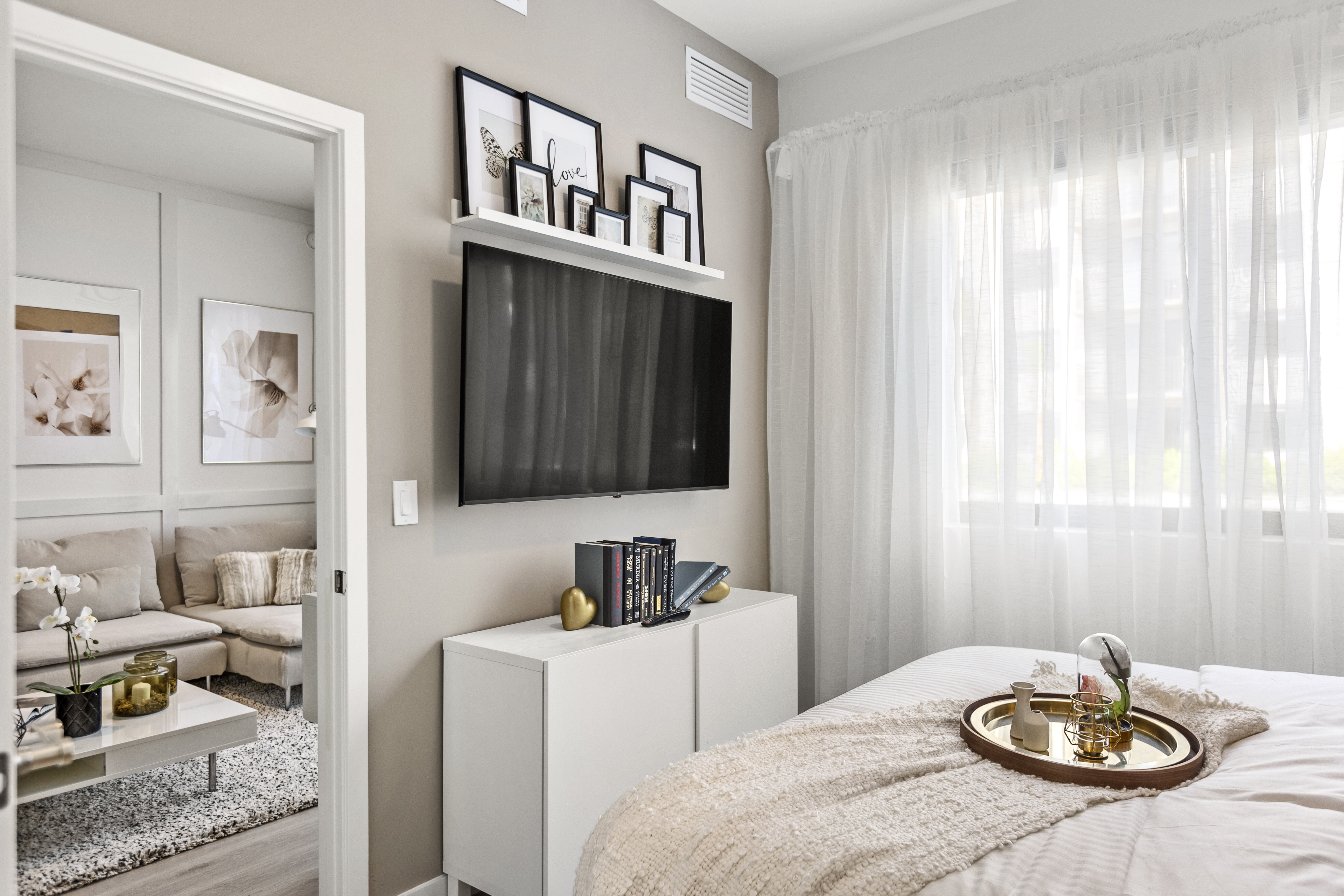 Enjoy the abundance of natural light and sleek modern furnishings in a furnished apartment model bedroom with wood-style flooring at Pine Ridge in West Palm Beach, Florida