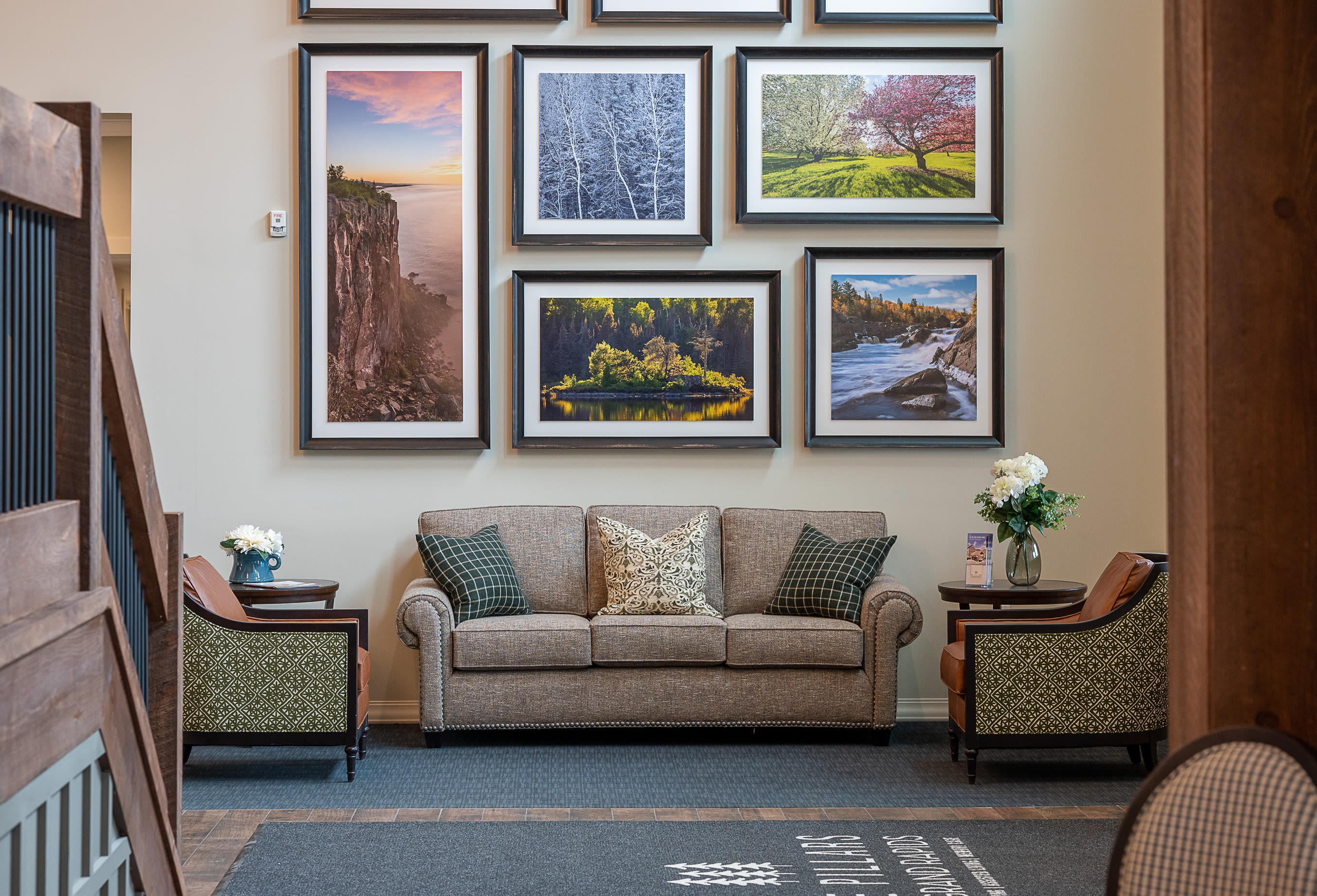 Sofa and chairs against a wall with multiple framed photos at The Pillars of Grand Rapids in Grand Rapids, Minnesota