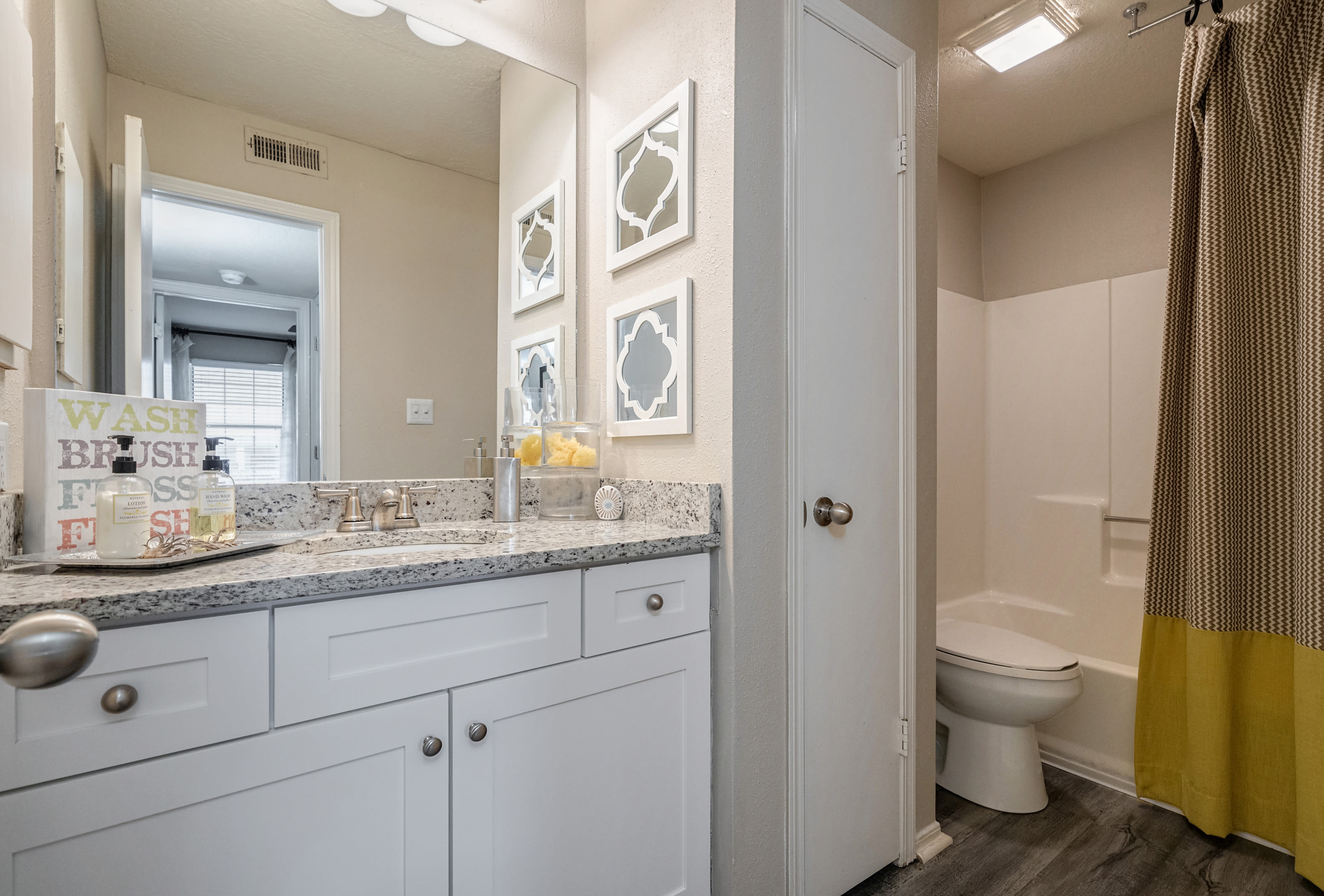 Bathroom with linen closet and tub/shower combination at Castlegate Collier Hills in Atlanta, Georgia