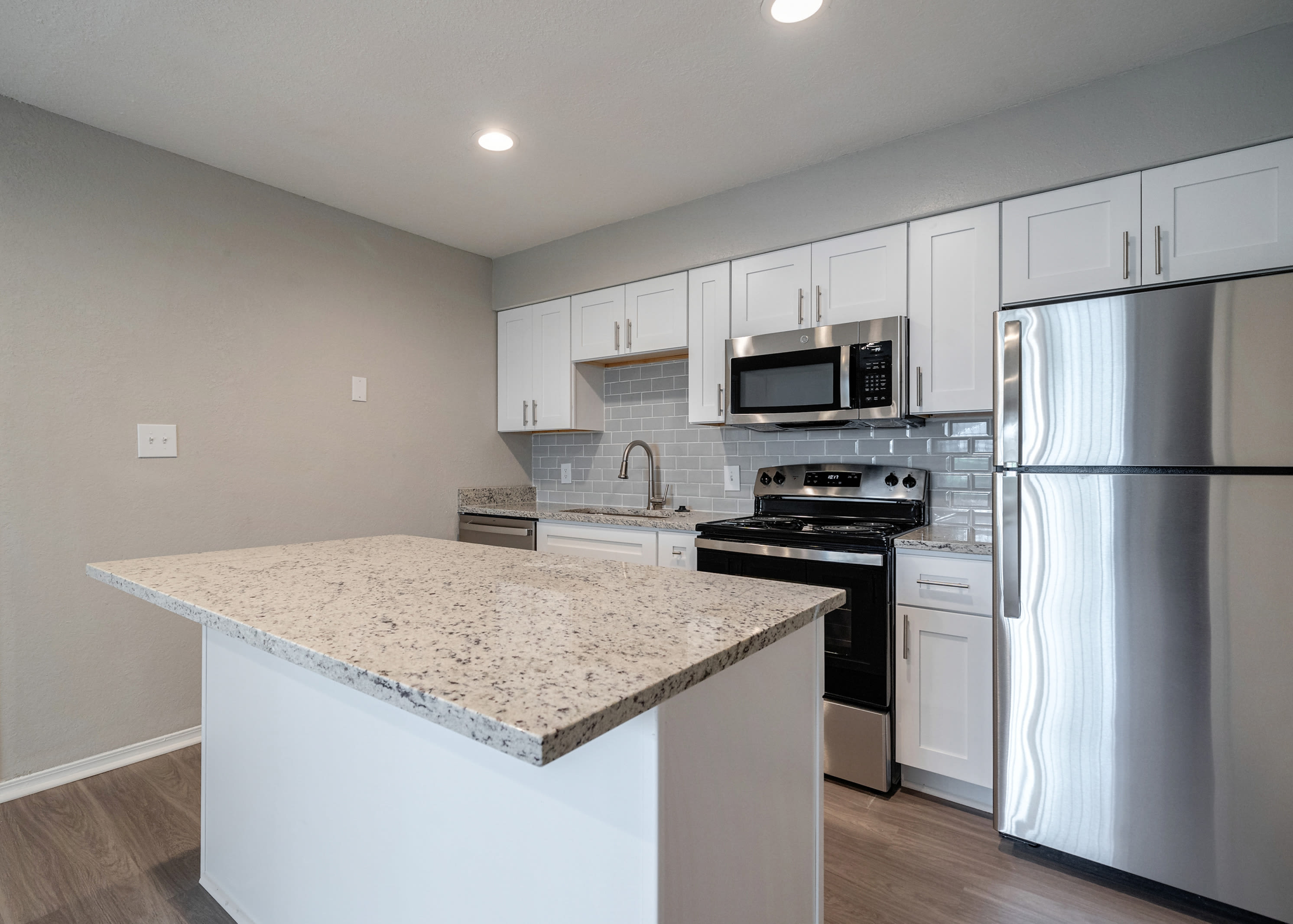 Fully equipped kitchen opening onto a dining area in a model home at Castlegate Collier Hills in Atlanta, Georgia