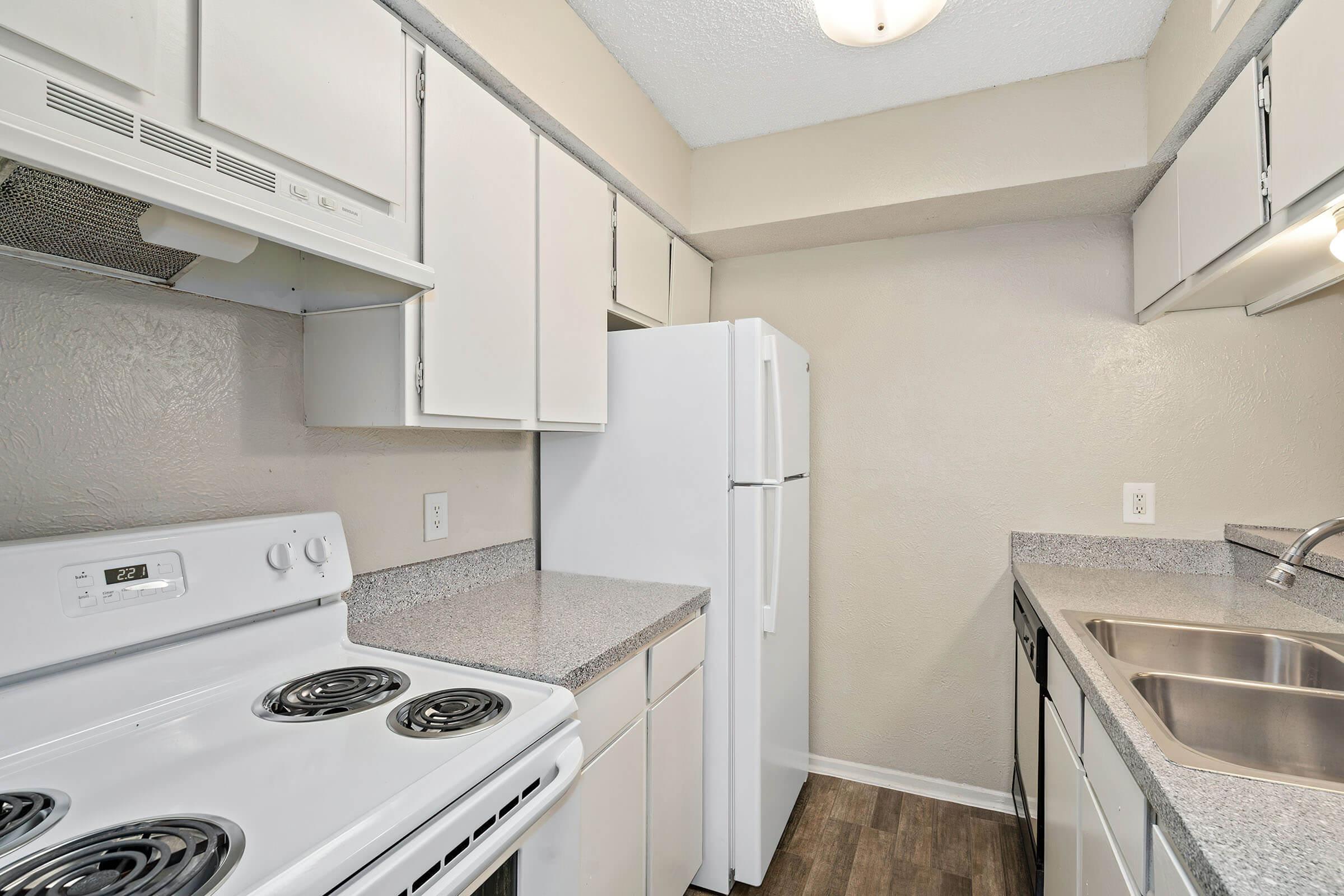 Kitchen with white cabinetry and appliances at Tides on Avril in Fort Worth, Texas