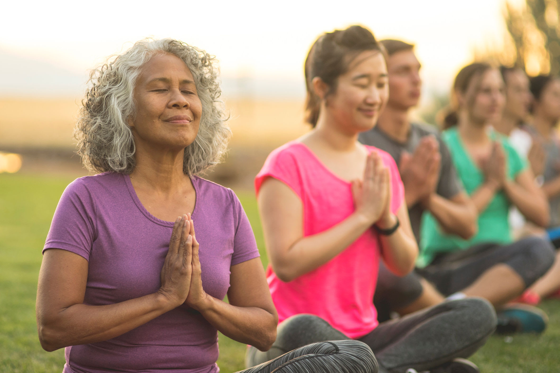 Close up of people making namaste gesture at yoga class outdoors at Ziegler Place in Livonia, Michigan
