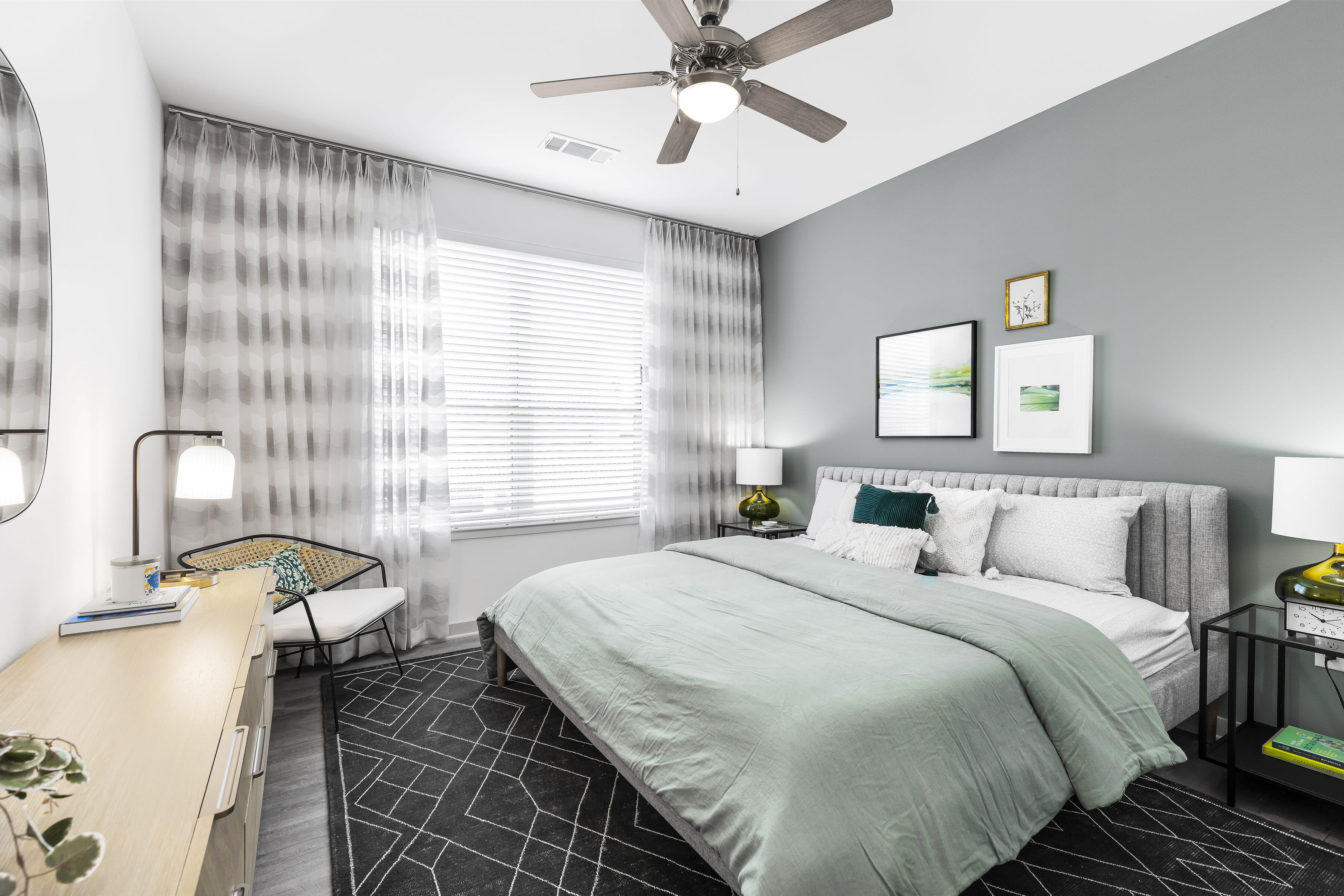 Model bedroom with natural light and a ceiling fan at The Warner in Round Rock, Texas