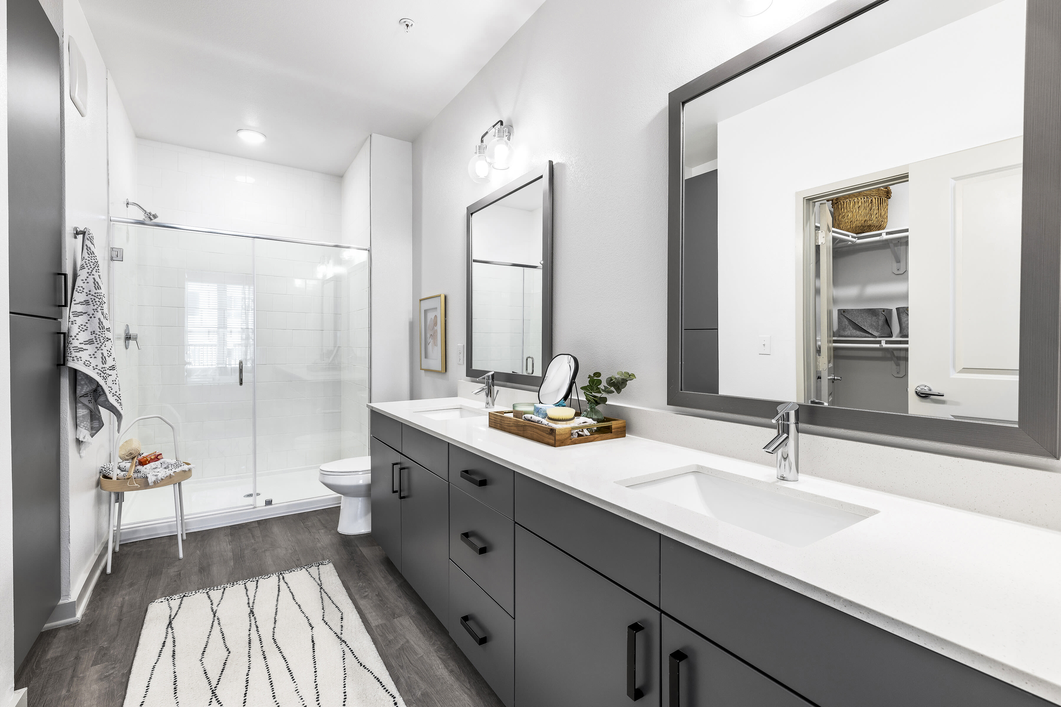 Model bathroom with two mirrors and modern furnishings at The Warner in Round Rock, Texas