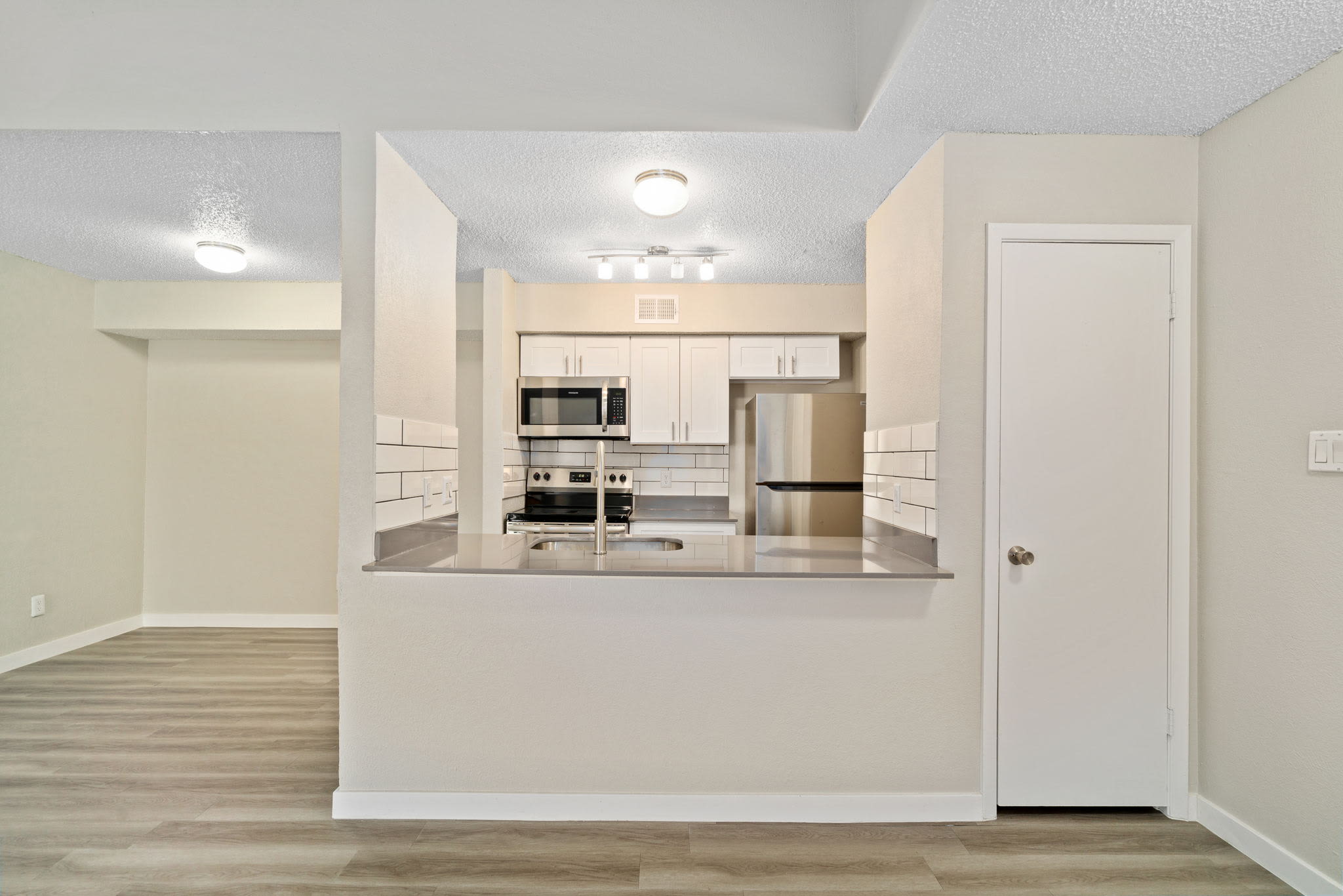 Kitchen with wood-style flooring at Tides on Avril in Fort Worth, Texas