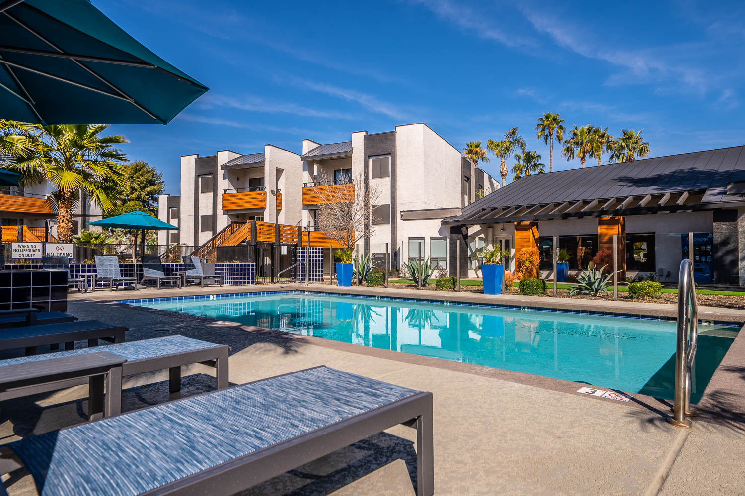 Lounge chairs by the resort-style swimming pool at Station 21 Apartments in Mesa, Arizona