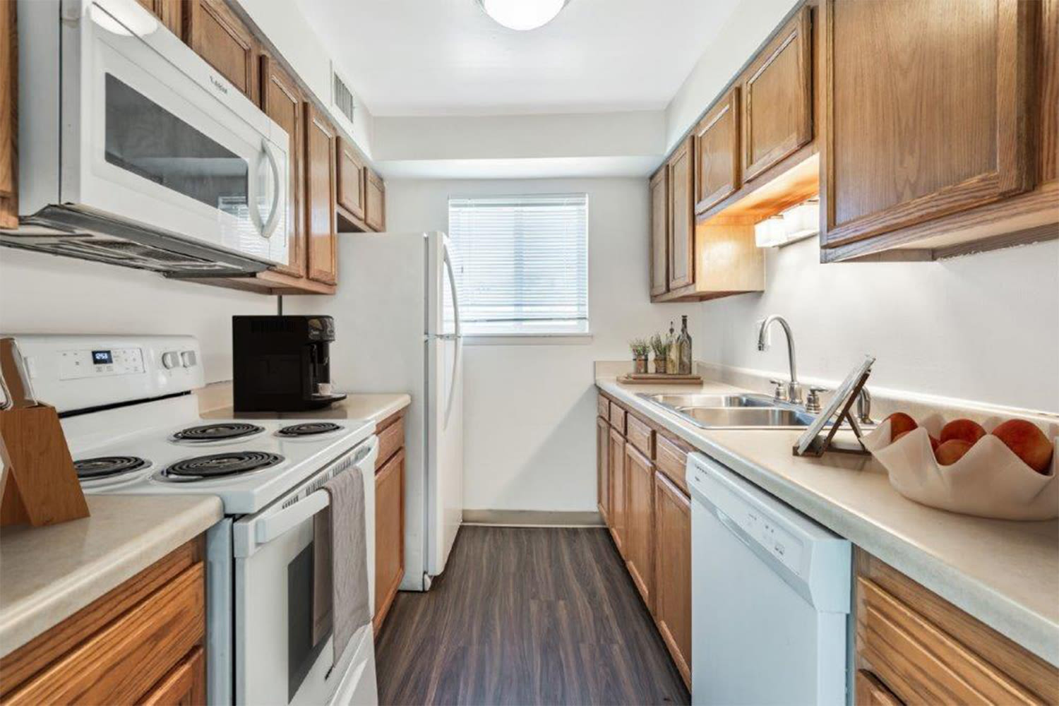 Fully equipped kitchen with sleek black appliances at Crossroads Apartments & Townhomes in Spencerport, New York