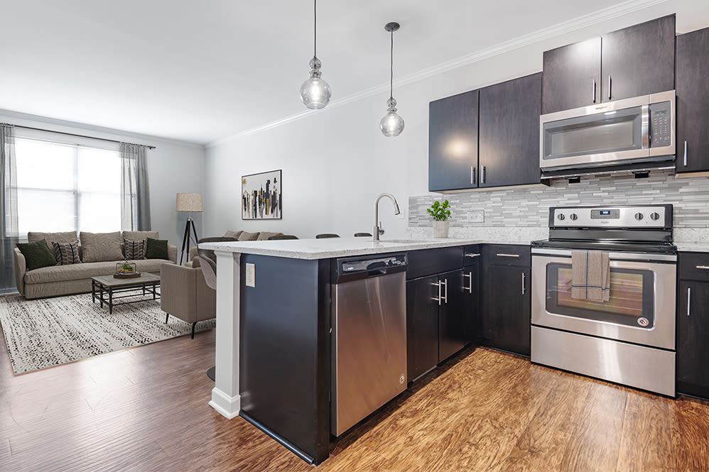 Contemporary kitchen with stainless steel appliances and quartz countertops at North Ponds Apartments & Townhomes in Webster, New York