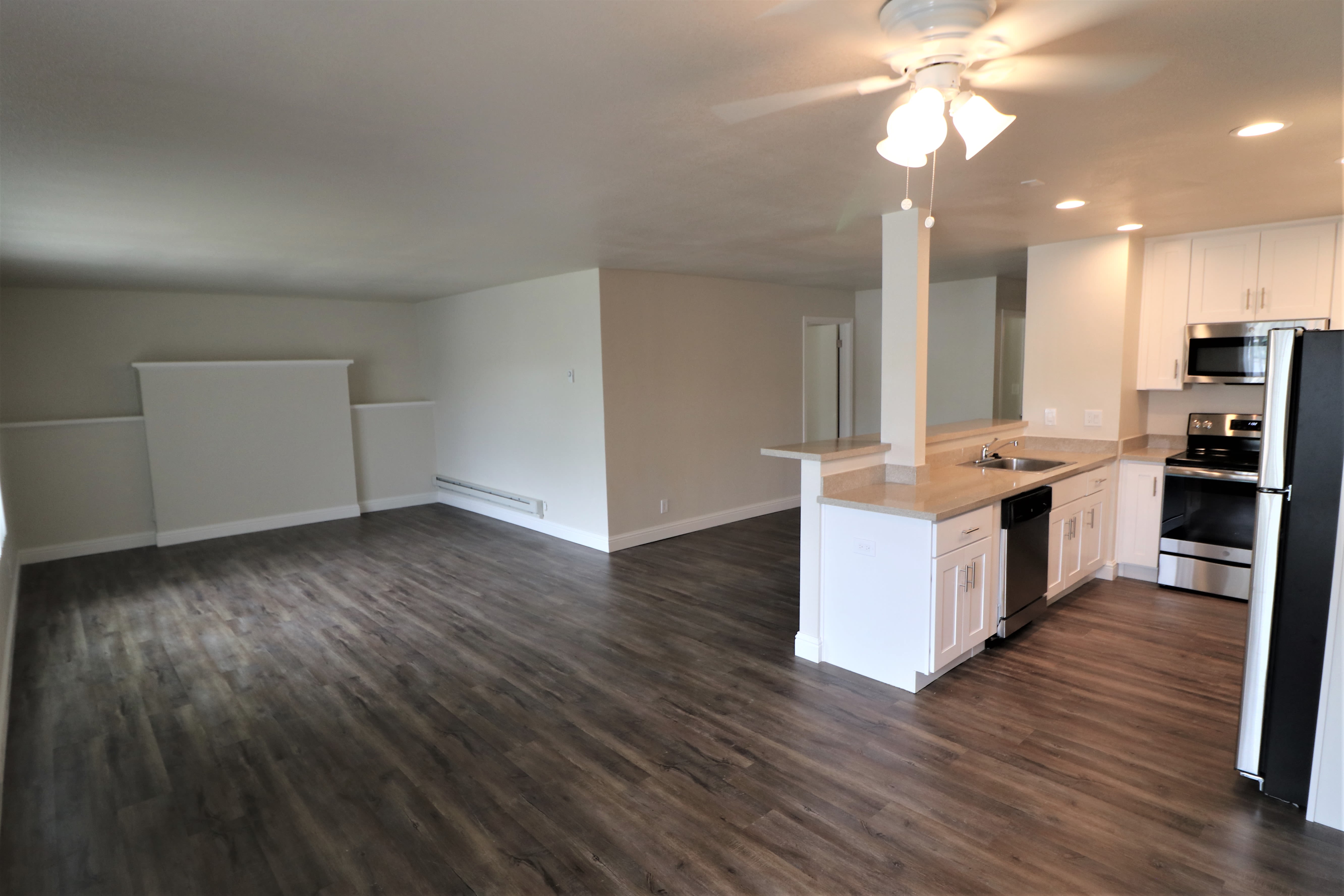 Kitchen, dining room and living room with wood-style flooring at Marina Haven Apartments in San Leandro, California