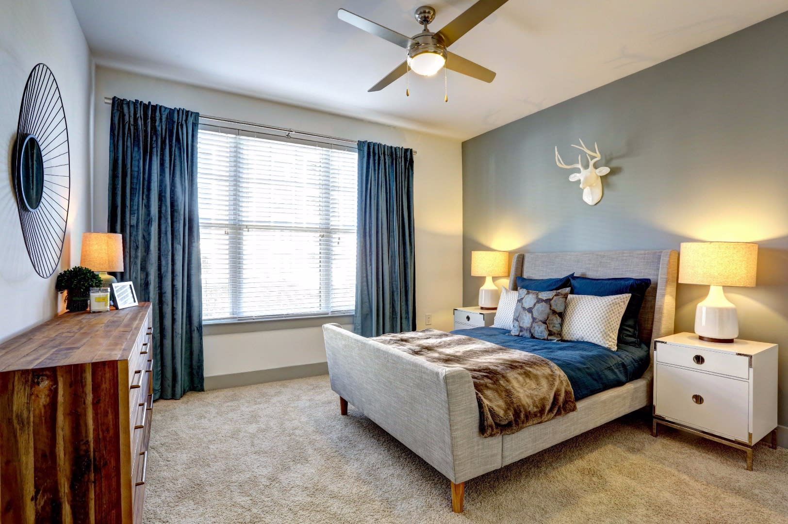 Dog-Friendly Apartments in Alpharetta, GA -The Haven at Avalon - Furnished Bedroom with Plush Carpeting, Large Window, and a Ceiling Fan