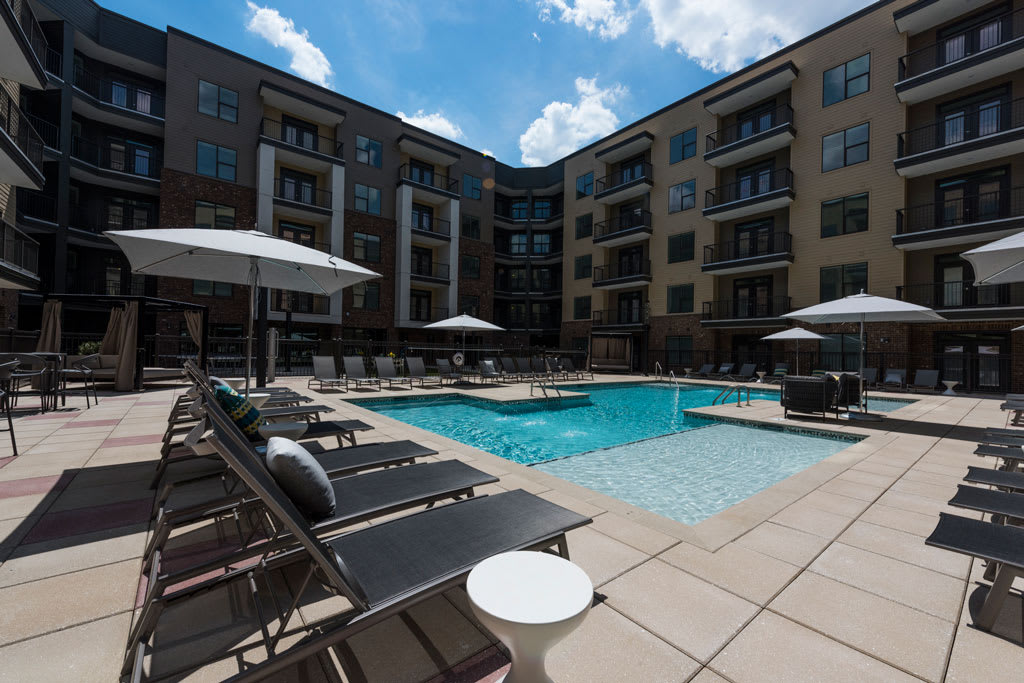Luxury Apartments For Rent In Alpharetta, GA - Veranda Avalon - Modern Plude Pool With In-Water Tanning Decks, Sundeck, Lounge Chairs, Tables, And Cabanas.