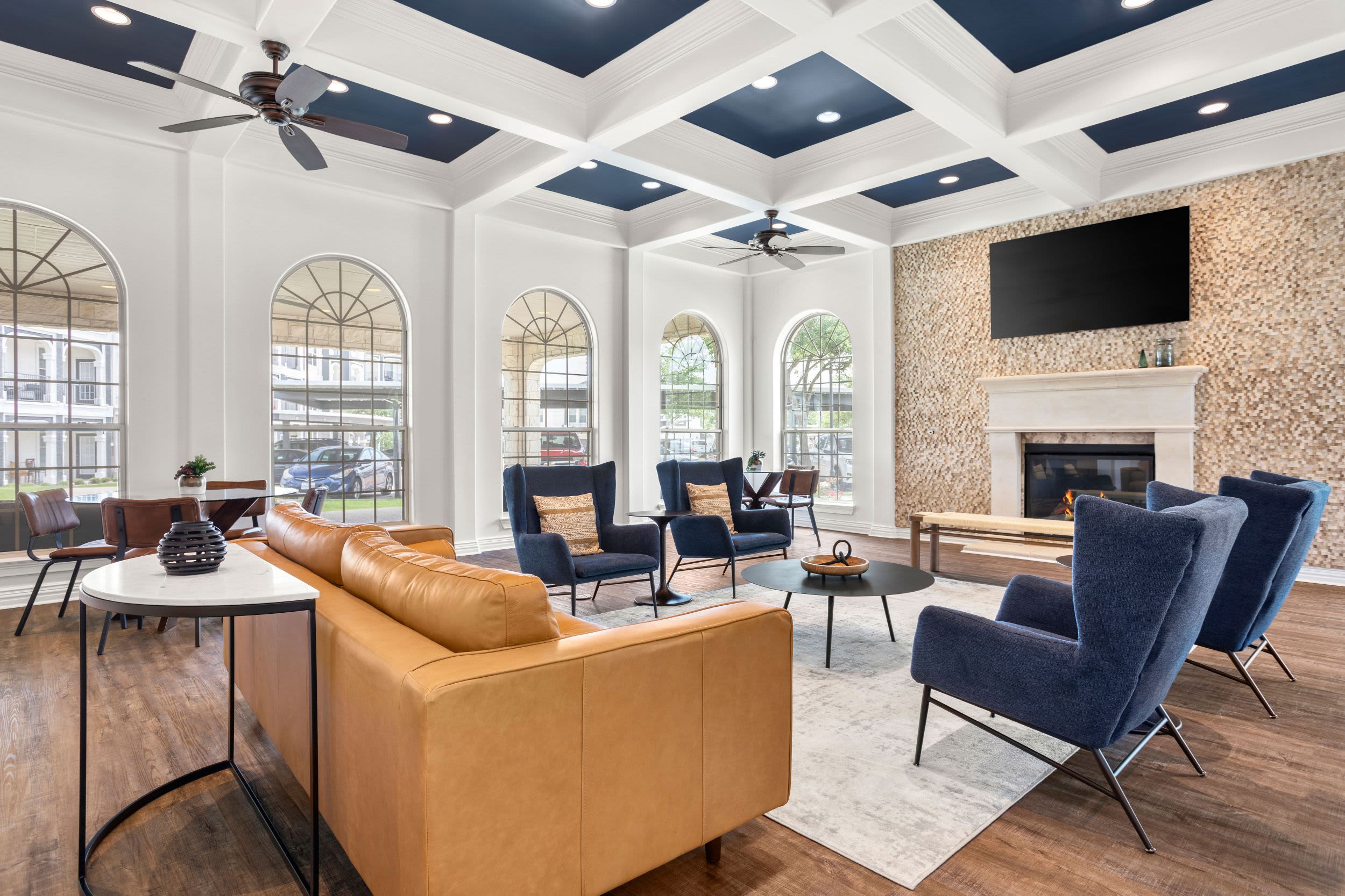 Luxurious resident clubhouse lounge in front of the fireplace at Olympus Woodbridge in Sachse, Texas