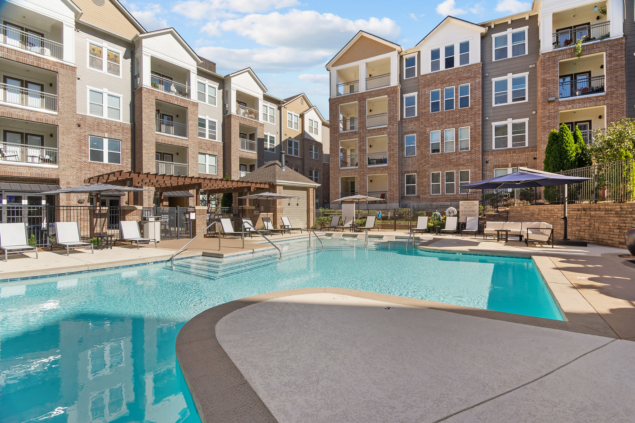 Resort-style swimming pool with sundeck lounge chairs at Artessa in Franklin, Tennessee