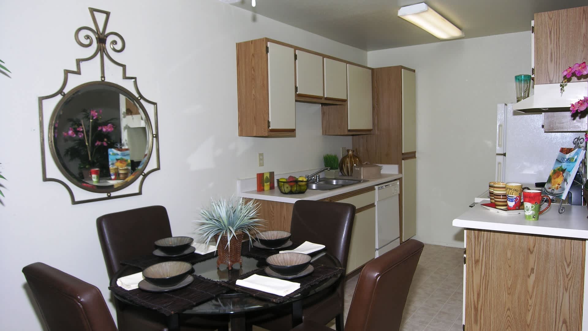 Fully furnished kitchen with white countertops and dining area at Country Views Apartments in Fallbrook, California
