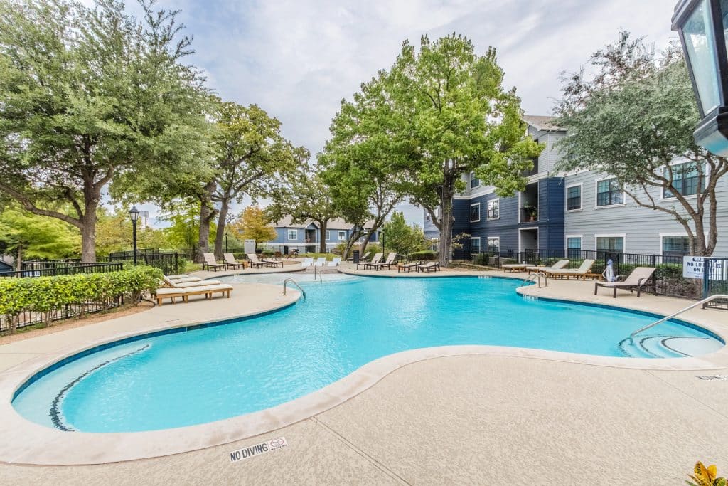 Swimming pool surrounded by green trees at Urban House in Dallas, Texas