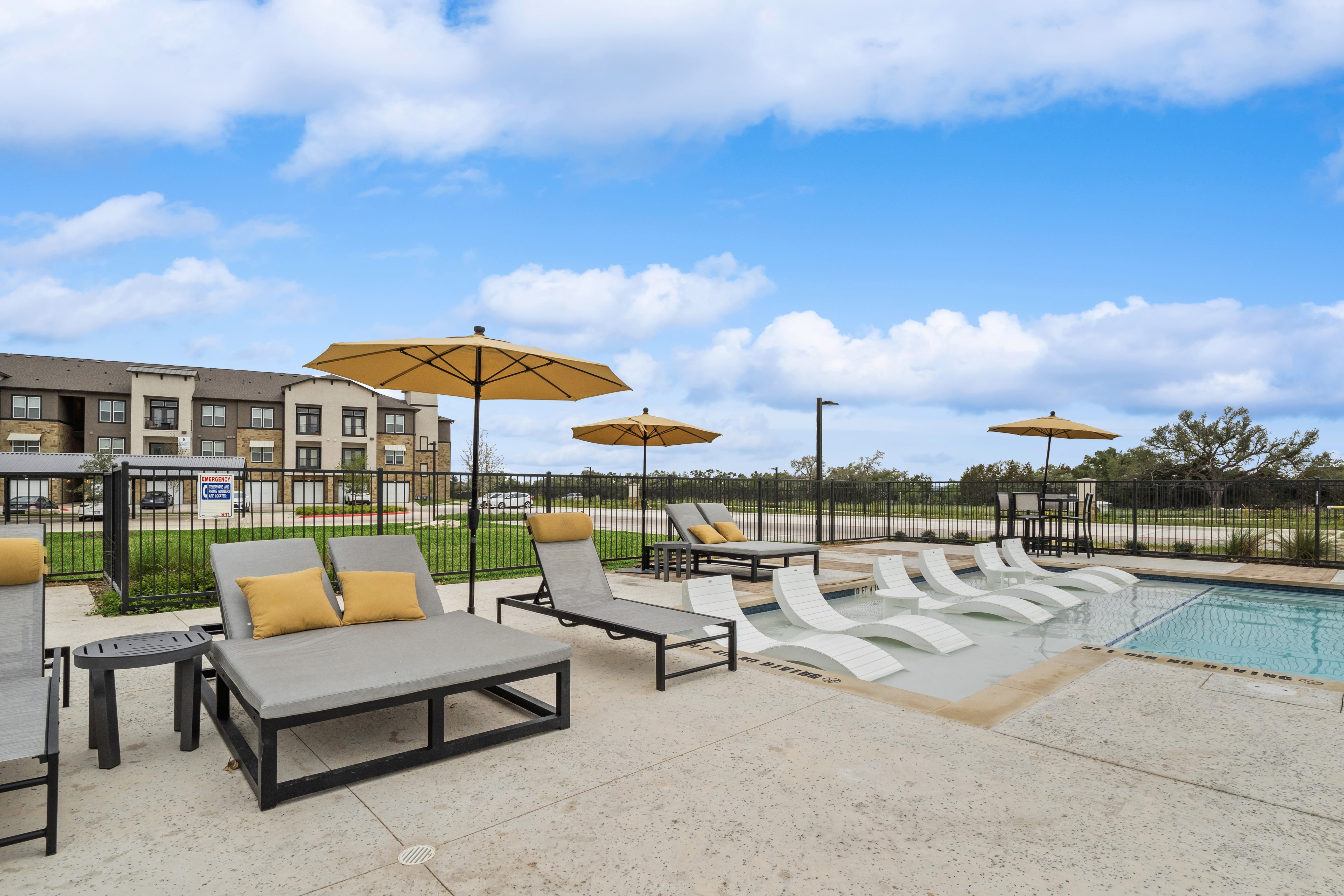Lounge seating facing the community swimming pool at Radius Wolf Ranch in Georgetown, Texas