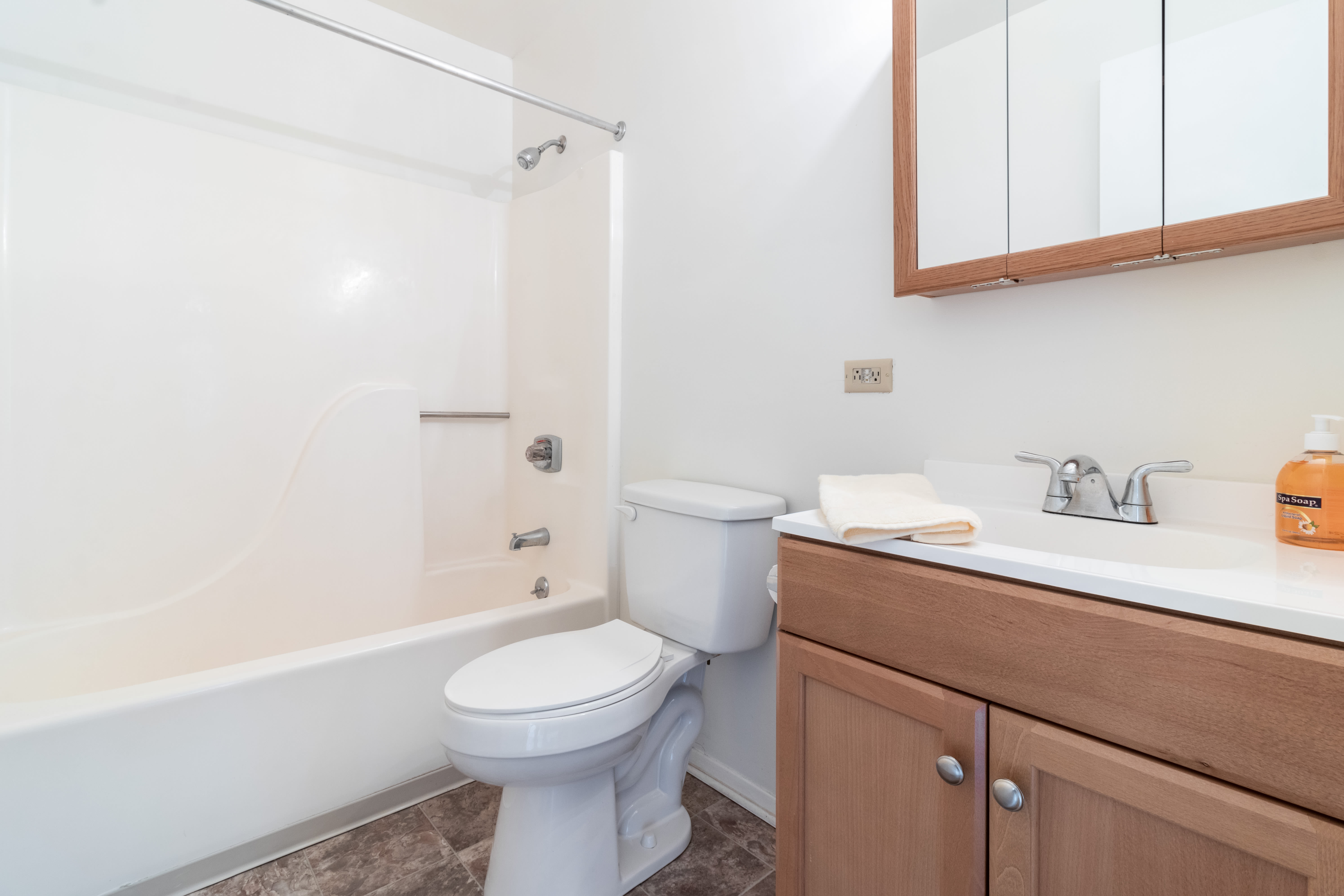 Bright bathroom with tub , shower and storage space at Arbor Crest Apartments in Charlottesville, Virginia