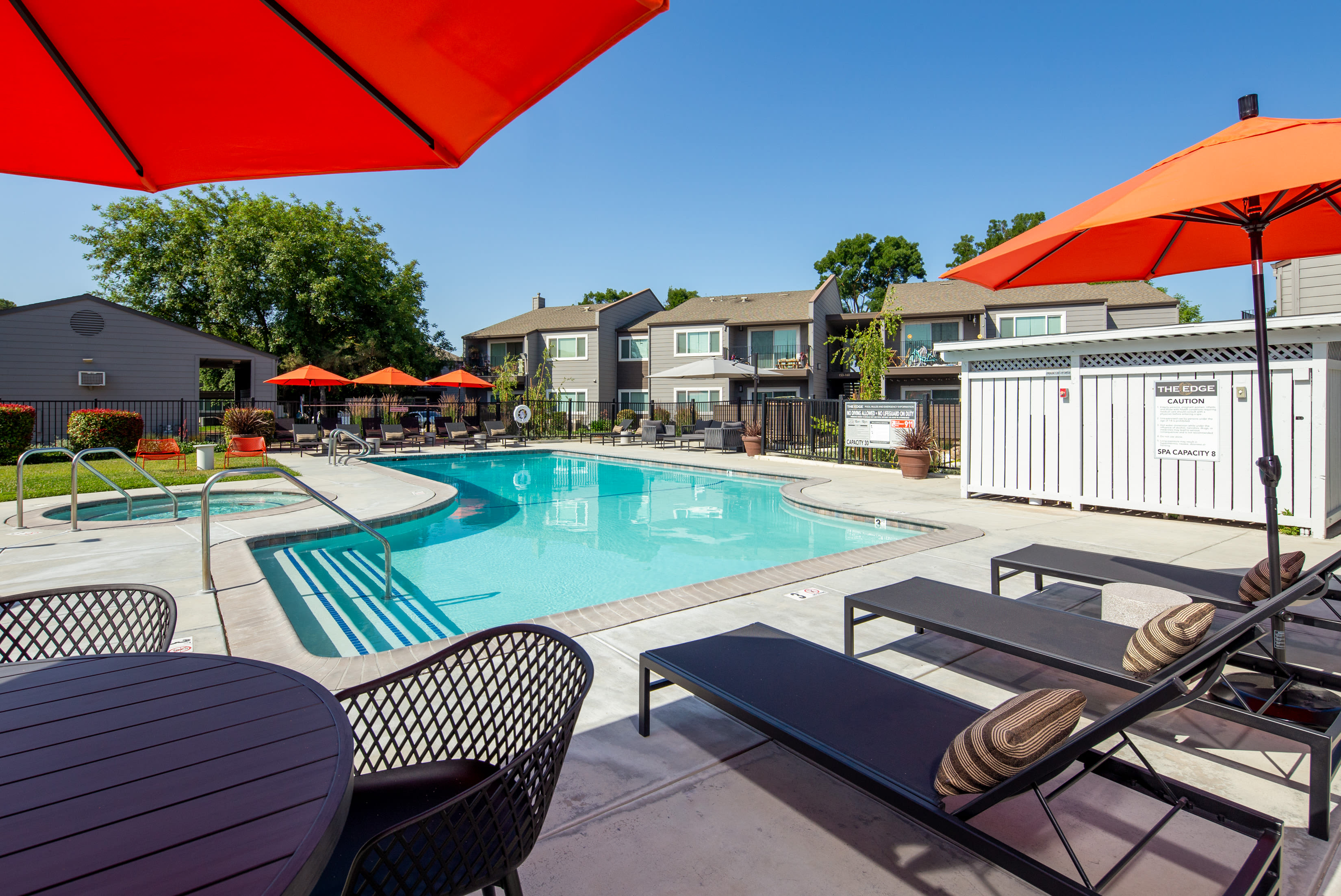 Swimming pool with lounge chairs at The Edge in Modesto, California
