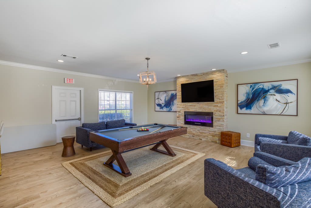 Resident lounge with a fireplace and pool table at Spring Lake in Byram, Mississippi