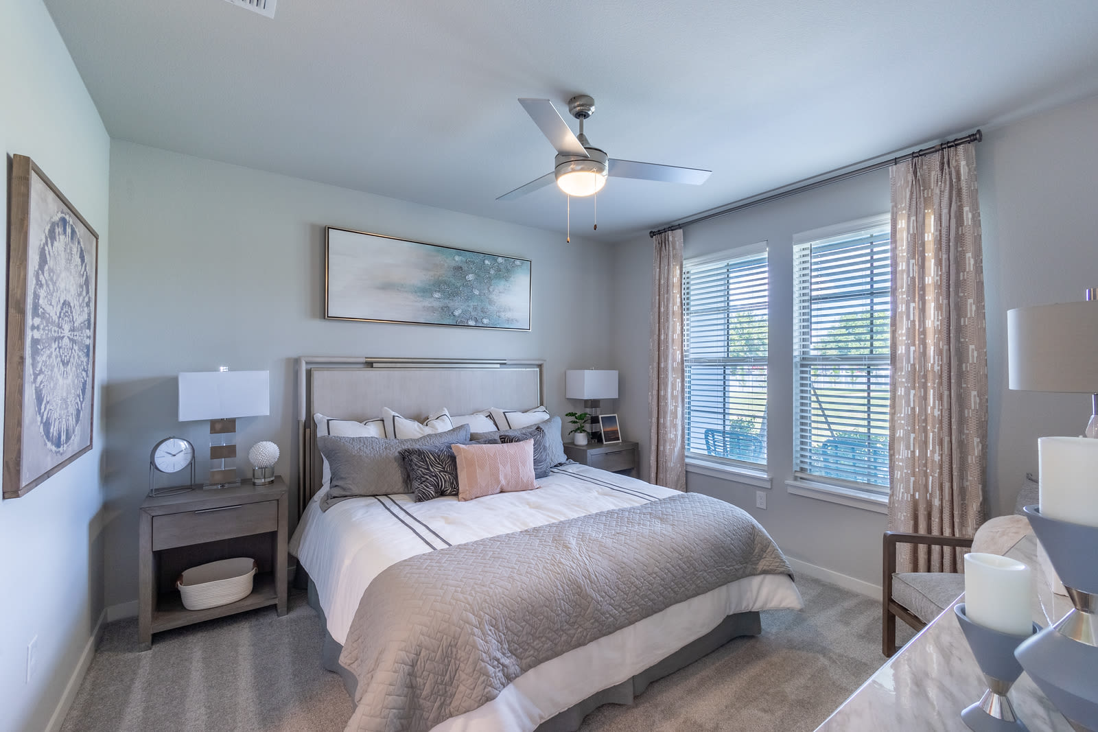 Large bedroom with plush carpeting, comfortable bed, fan and windows at Indigo Champions Ridge in Davenport, Florida