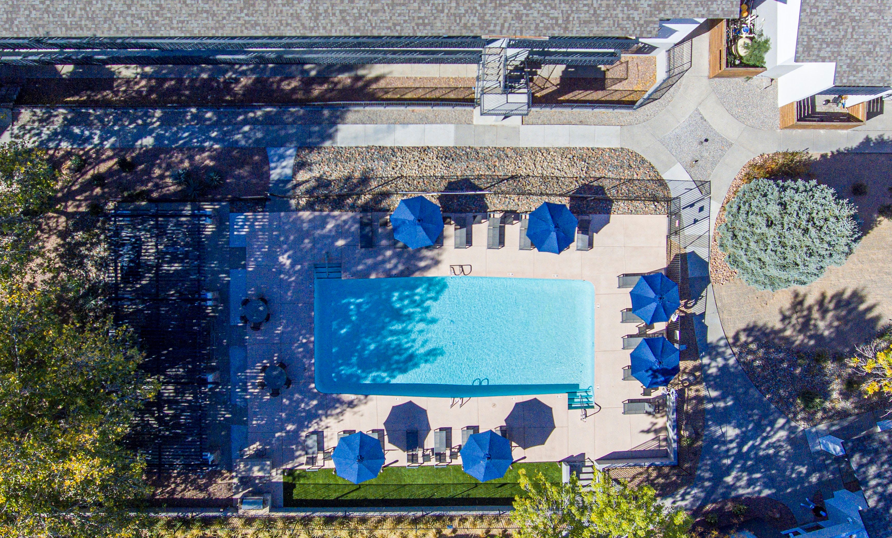 Aerial view of pool with blue umbrellas at  Montecito in Albuquerque, New Mexico