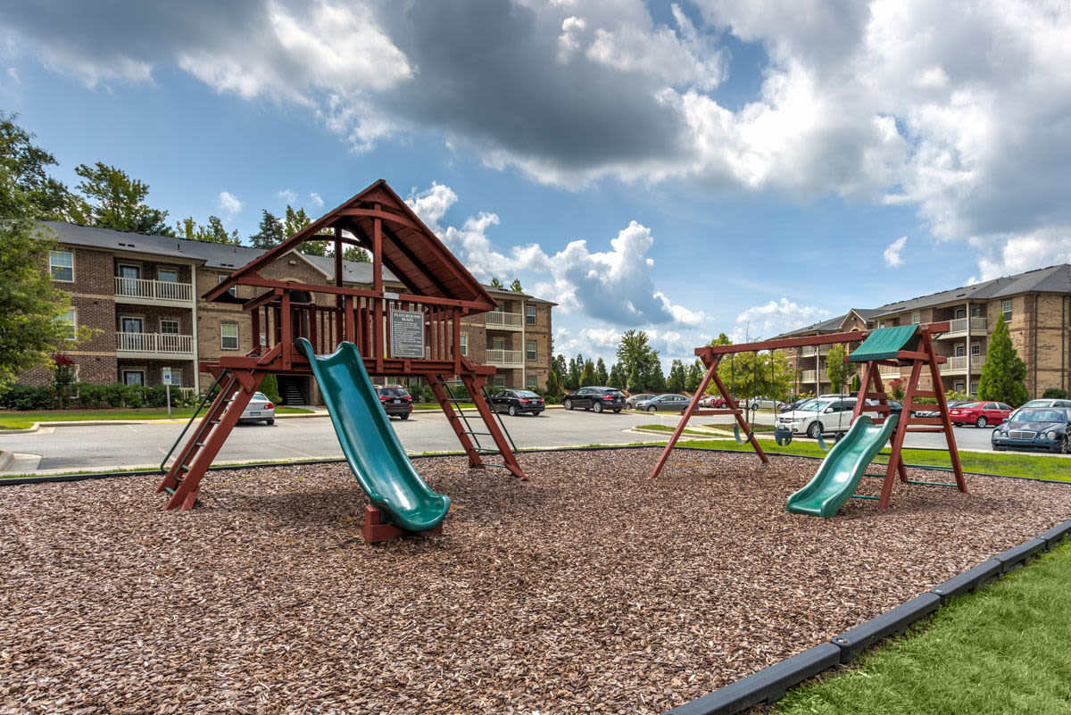Playground with slides and jungle gyms on a soft mulch surface at Innisbrook Village in Greensboro, North Carolina