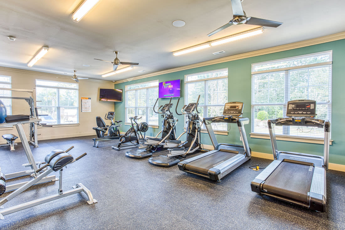 Fully-equipped gym with treadmills, weight machines, and flat-screen TVs at Beckstone Apartments in Summerville, South Carolina