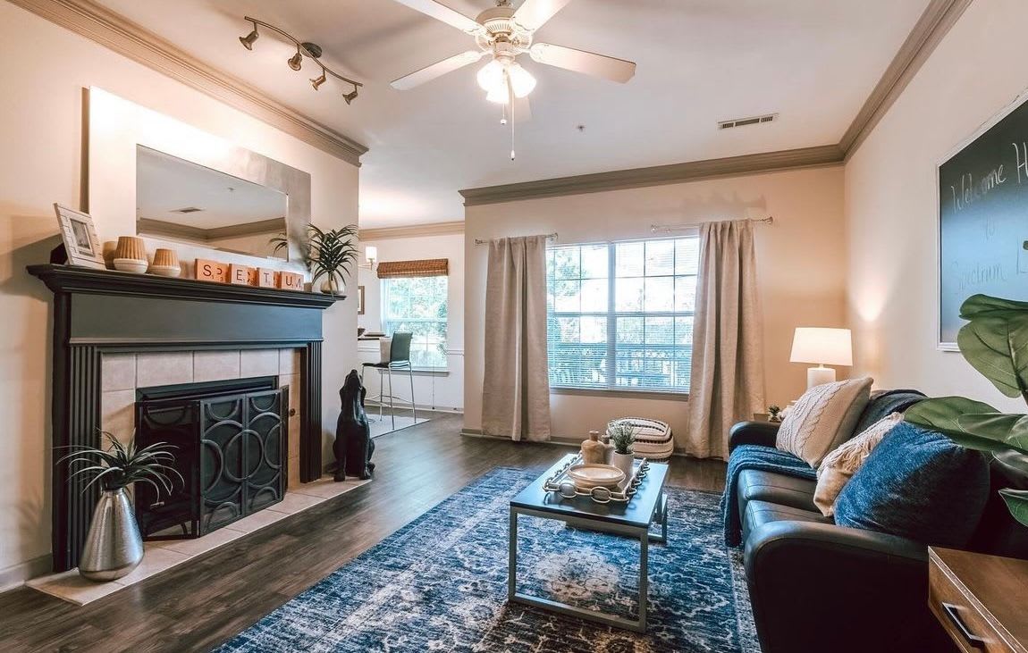 Apartment living room with fireplace and ceiling fan at The Landing at Fayetteville in Fayetteville, Arkansas