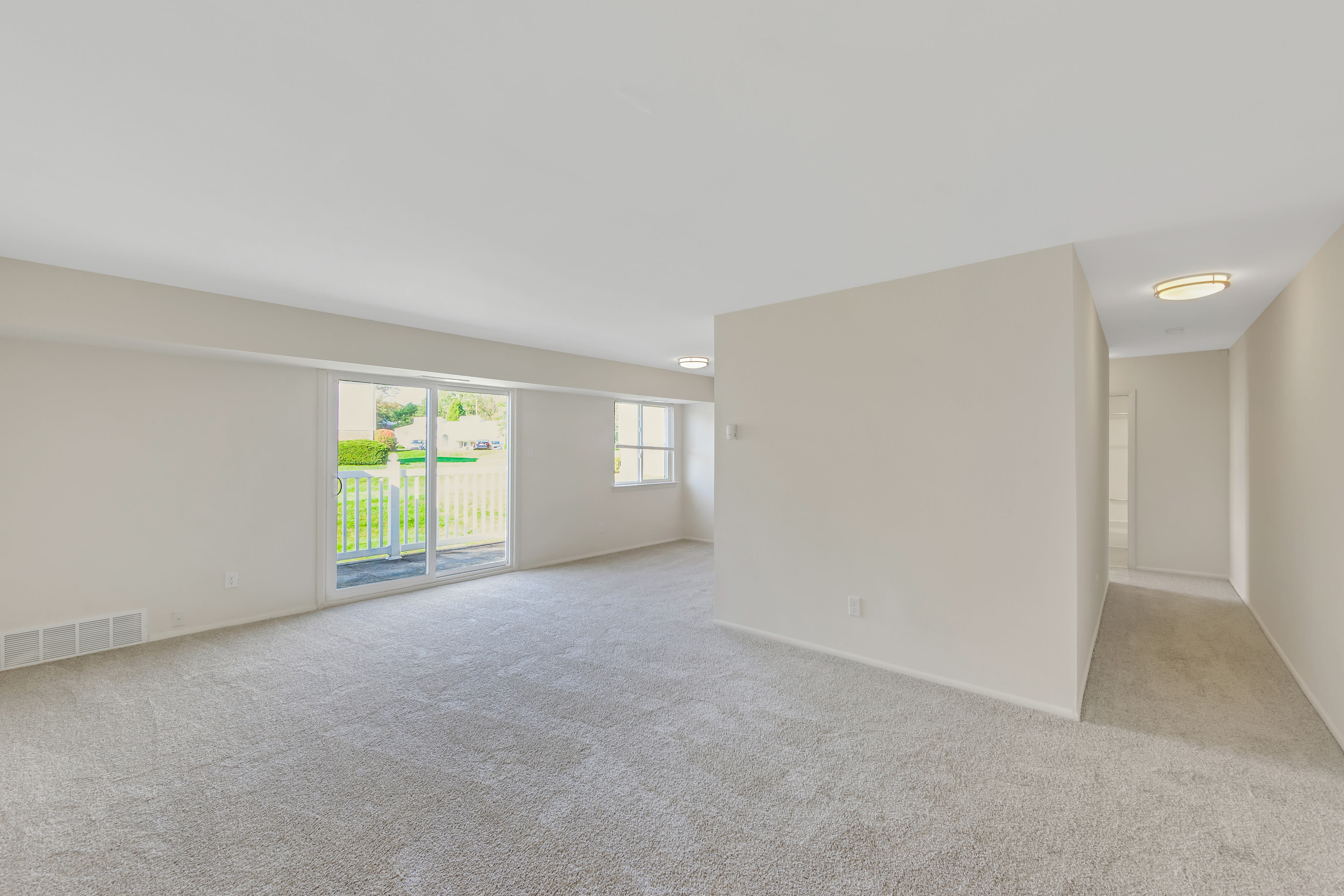 A living room featuring sliding glass door and close access to patio at Blair Mill Village East Apartment Homes, Horsham, Pennsylvania