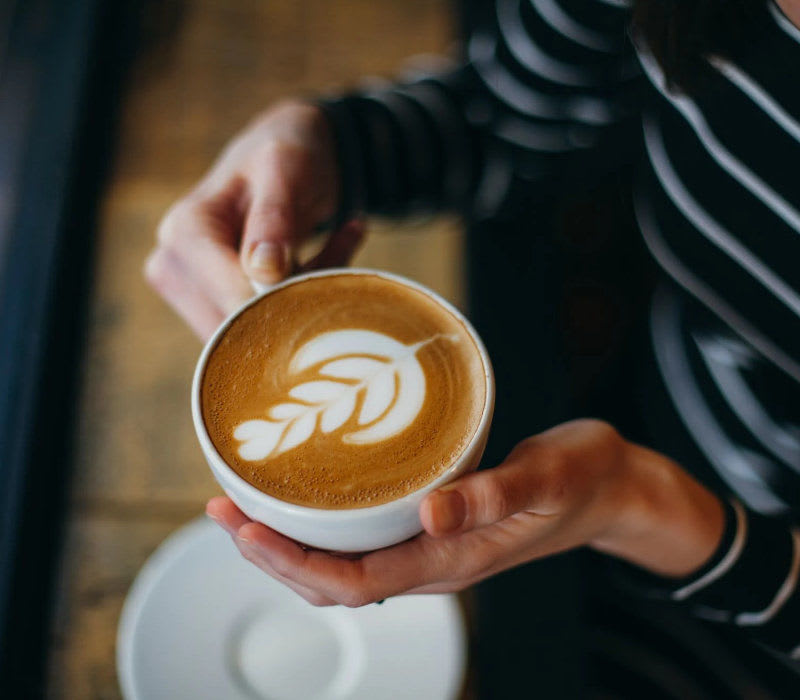 Resident holding a cup of coffee at The Beacon in Fremont, California