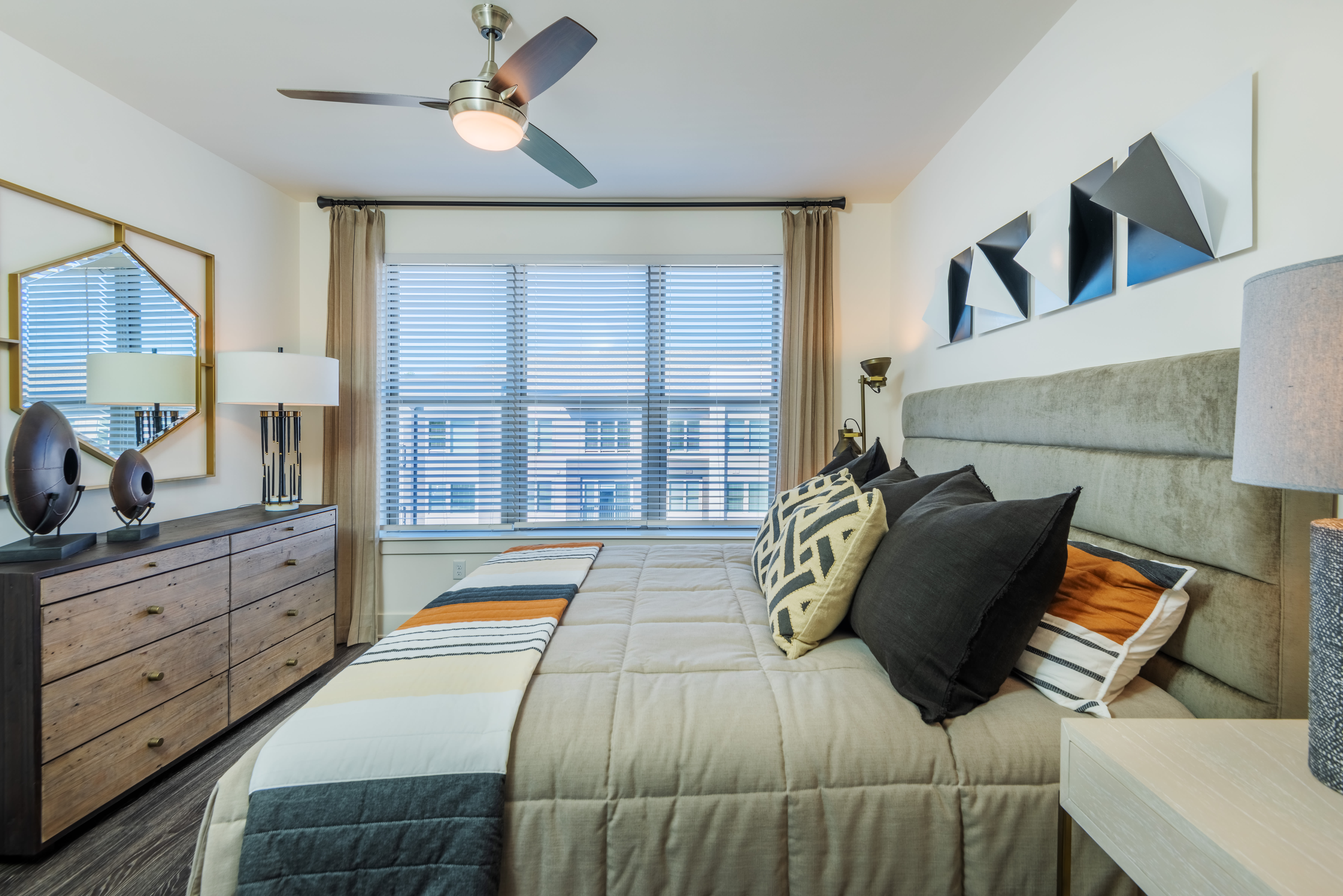 Well-lit and spacious bedroom with ceiling fans and lamps at The Reverie At Lake Boone in Raleigh, North Carolina